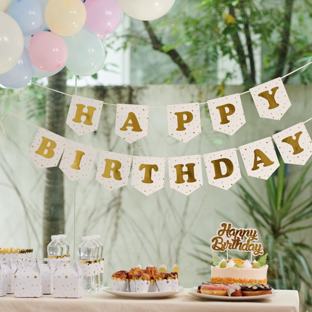 Kindergeburtstag zuhause feiern: Geburtstagstisch mit Happy-Birthday-Girlande.