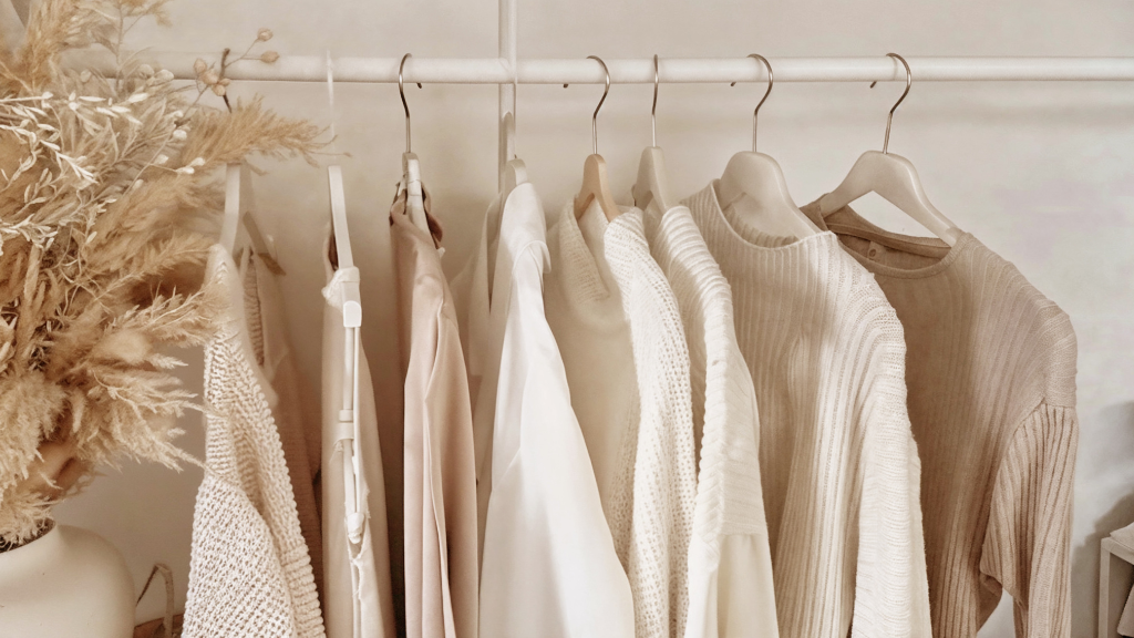 Kleidung hängt auf Kleiderstange.