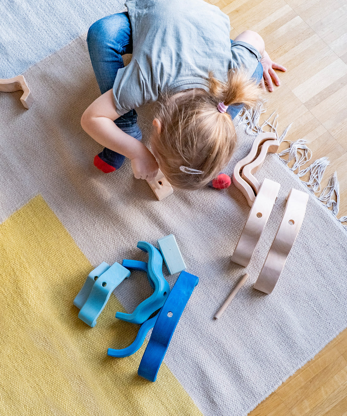 Kind spielt mit Holzspielzeug Wolke, von Montessori inspiriert.