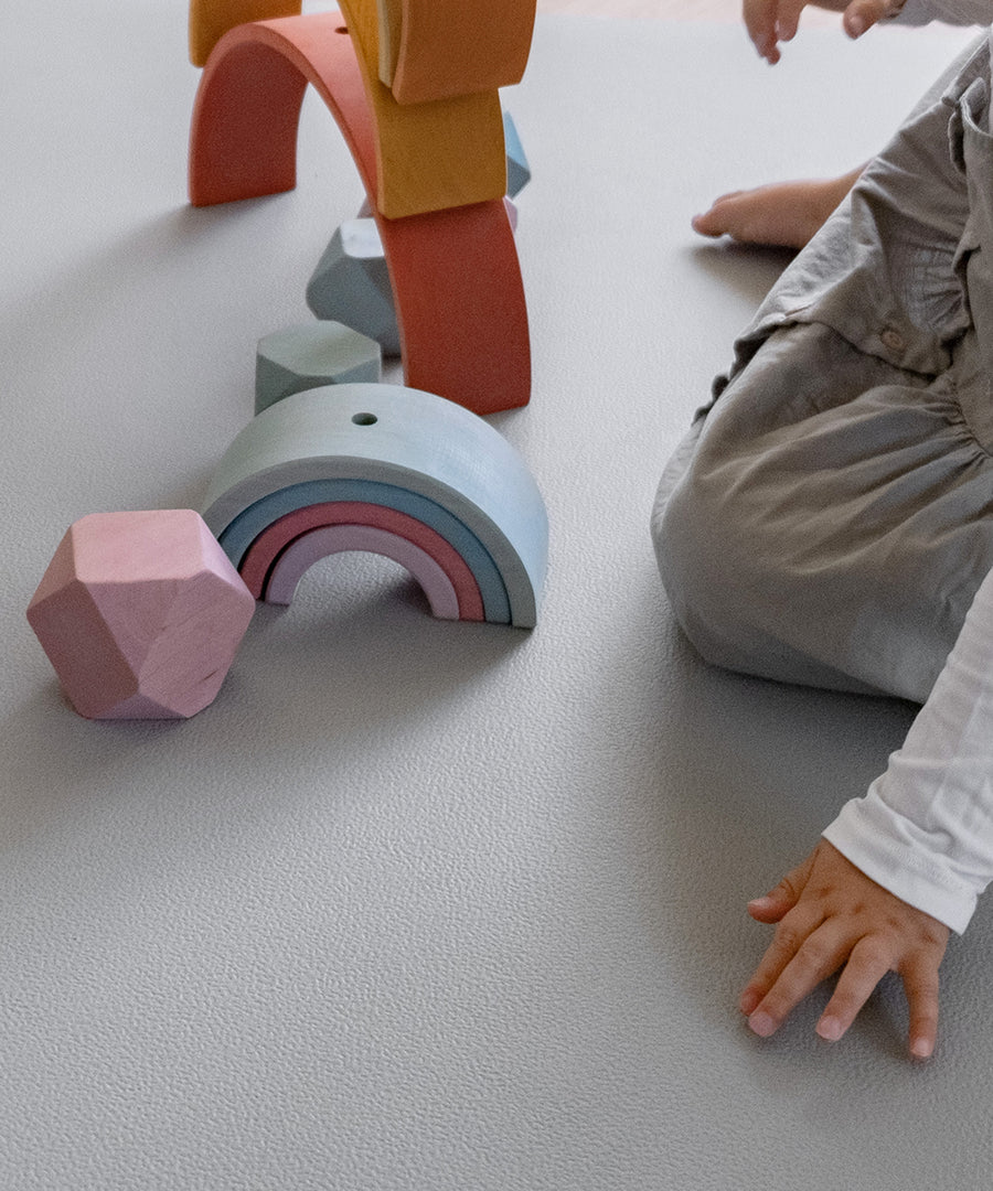 Kinder spielen mit Holzspielzeug auf Krabbelmatte Pro Hellgrau.