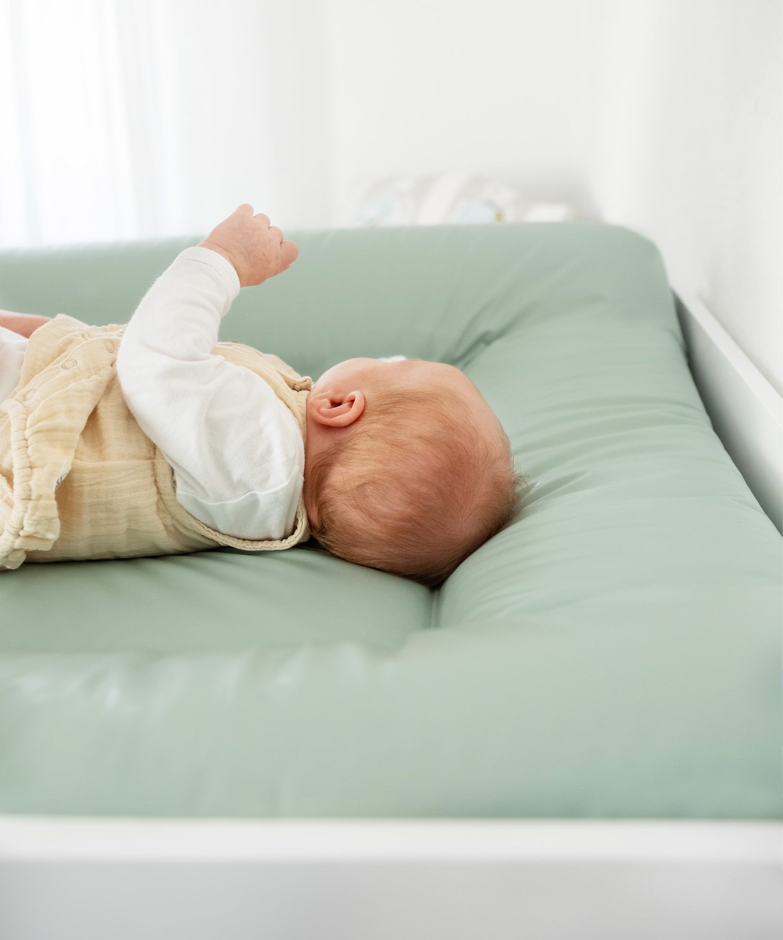 Baby auf Wickelauflage abwaschbar in Jade, Wickelauflage ist weich gepolstert.