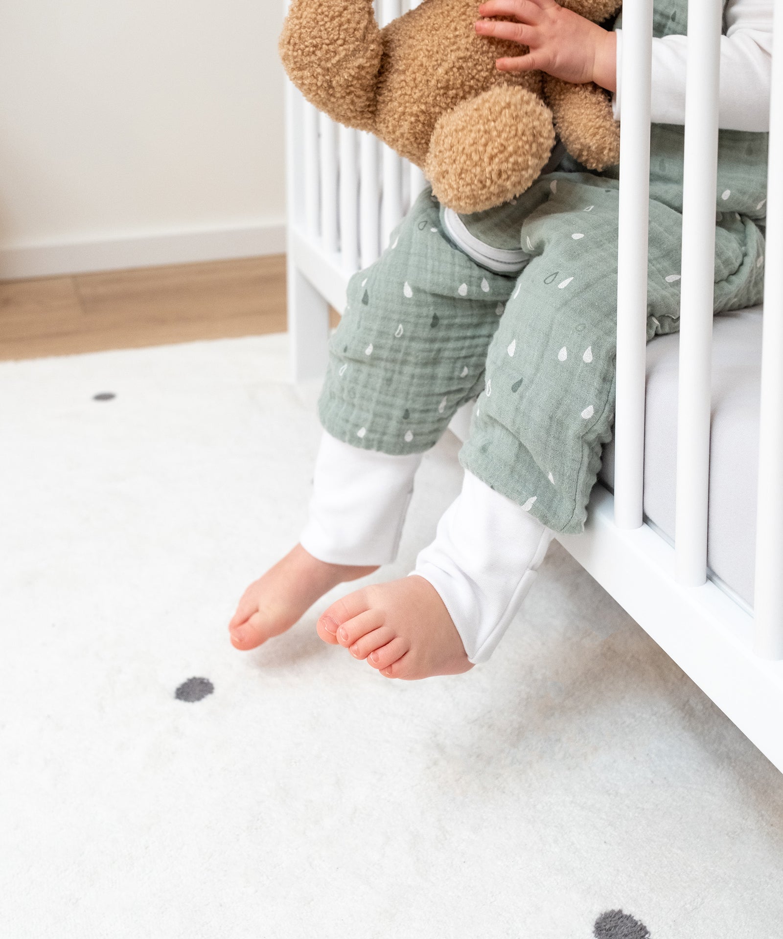 Herausnehmbare Stangen*Drei abnehmbare Stangen garantieren ein einfaches und sicheres Ein- und Aussteigen.|Kind sitzt in Betteingang, an dem die Stangen herausgenommen wurden.