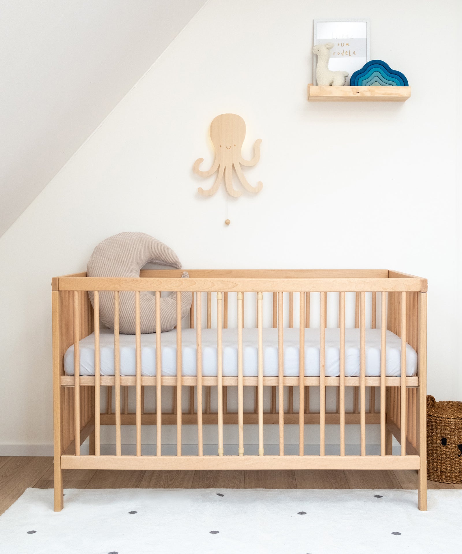 Höhenverstellbar*Die Höhe des Babybetts lässt sich individuell anpassen. So ist es flexibel und wächst mit deinem Kind mit.|Babybett Natur mit hoch gestellter Liegefläche in Kinderzimmer.