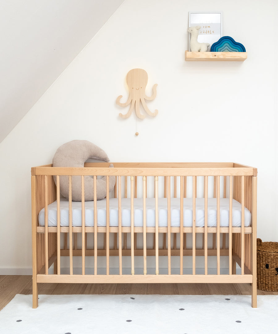 Höhenverstellbar*Die Höhe des Babybetts lässt sich individuell anpassen. So ist es flexibel und wächst mit deinem Kind mit.|Babybett Natur mit hoch gestellter Liegefläche in Kinderzimmer.
