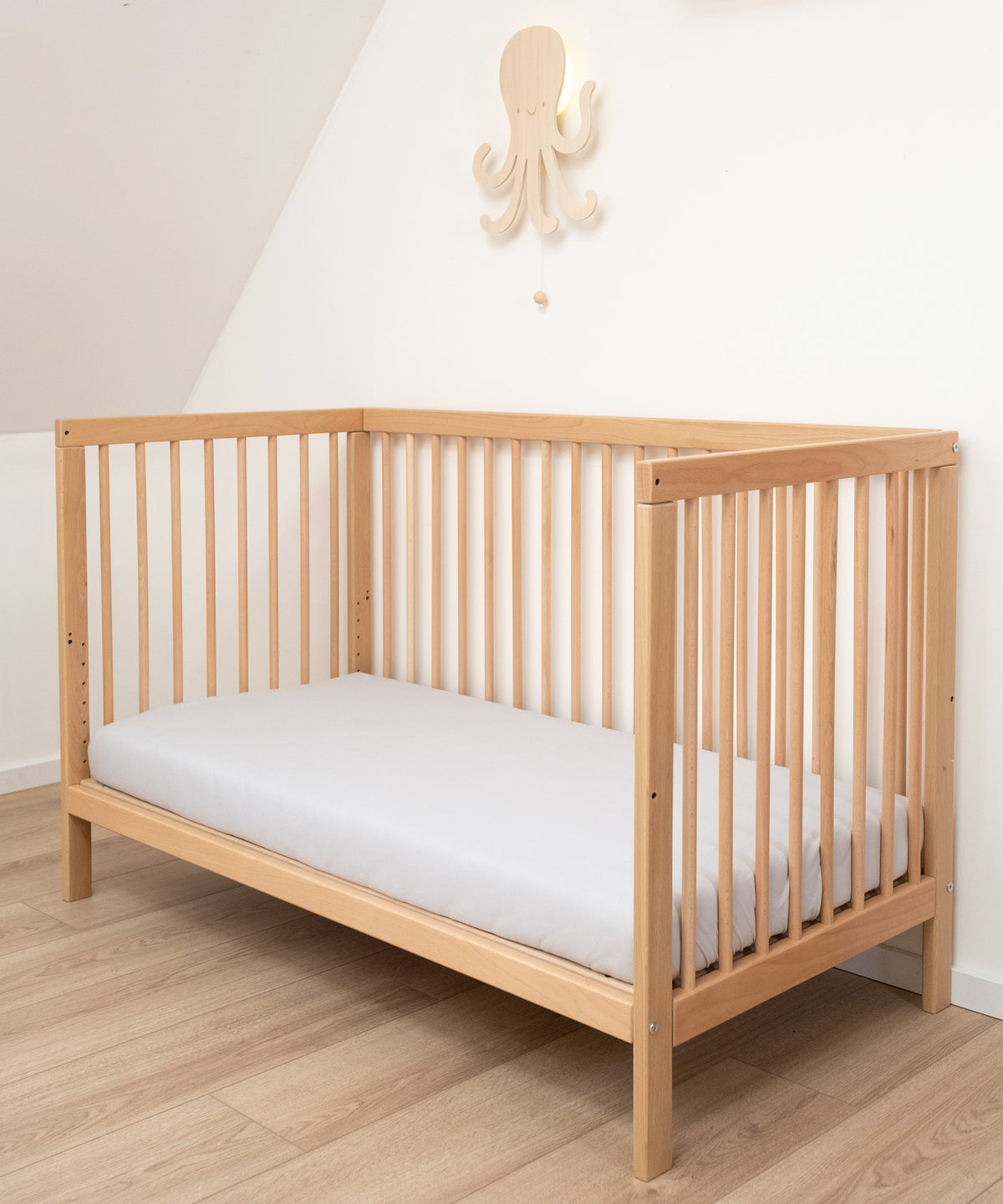 Babybett mit Matratze mit abgenommener Seite.