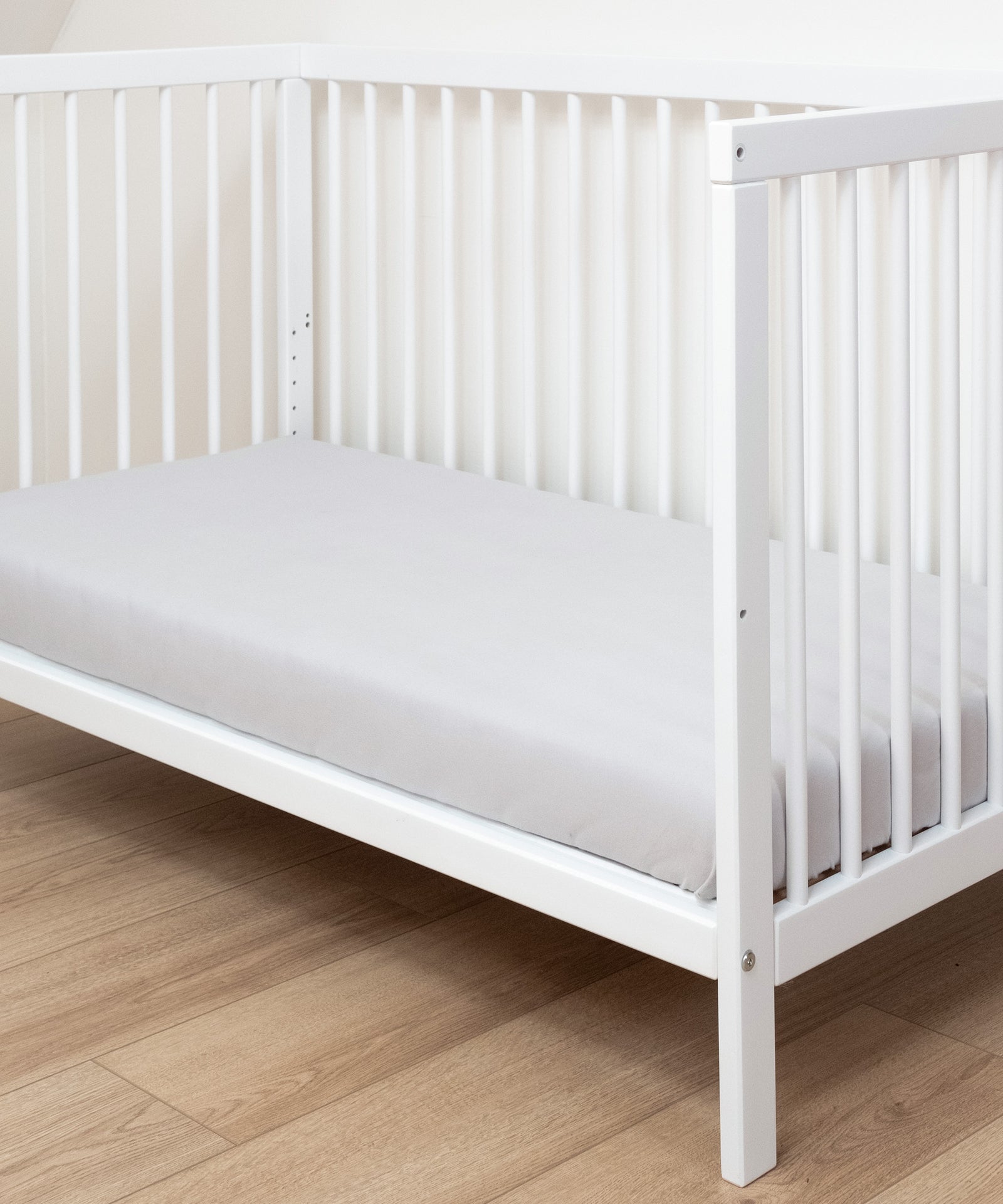 Babybett mit Matratze, eine Seite abmontiert.