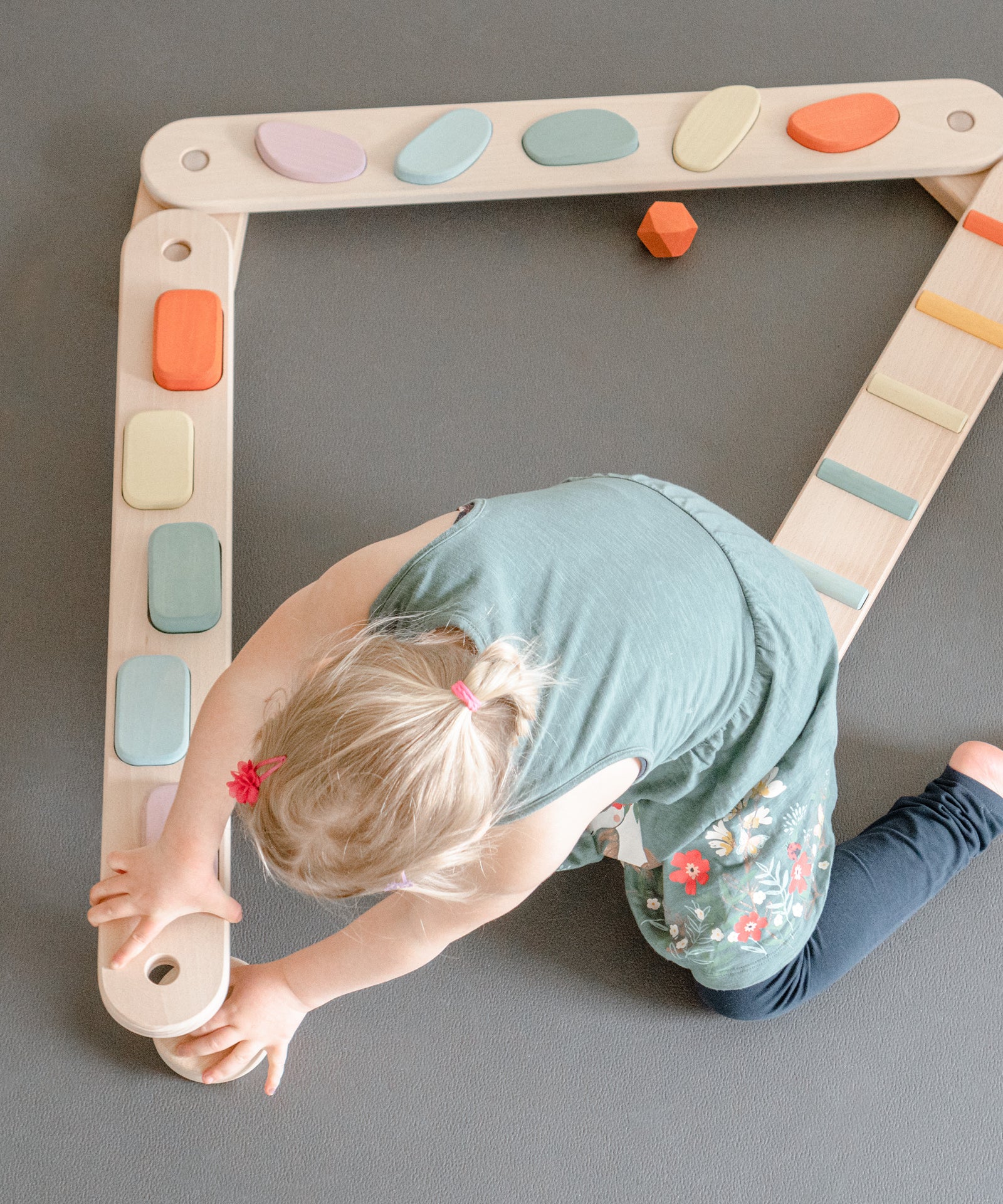 Raum für kreatives Spielen*Durch das modulare System können Kinder den Balancierbalken ganz einfach nach ihren Wünschen selbst umbauen.|Mädchen beim einfachen Umbau des Balancierbalkens.