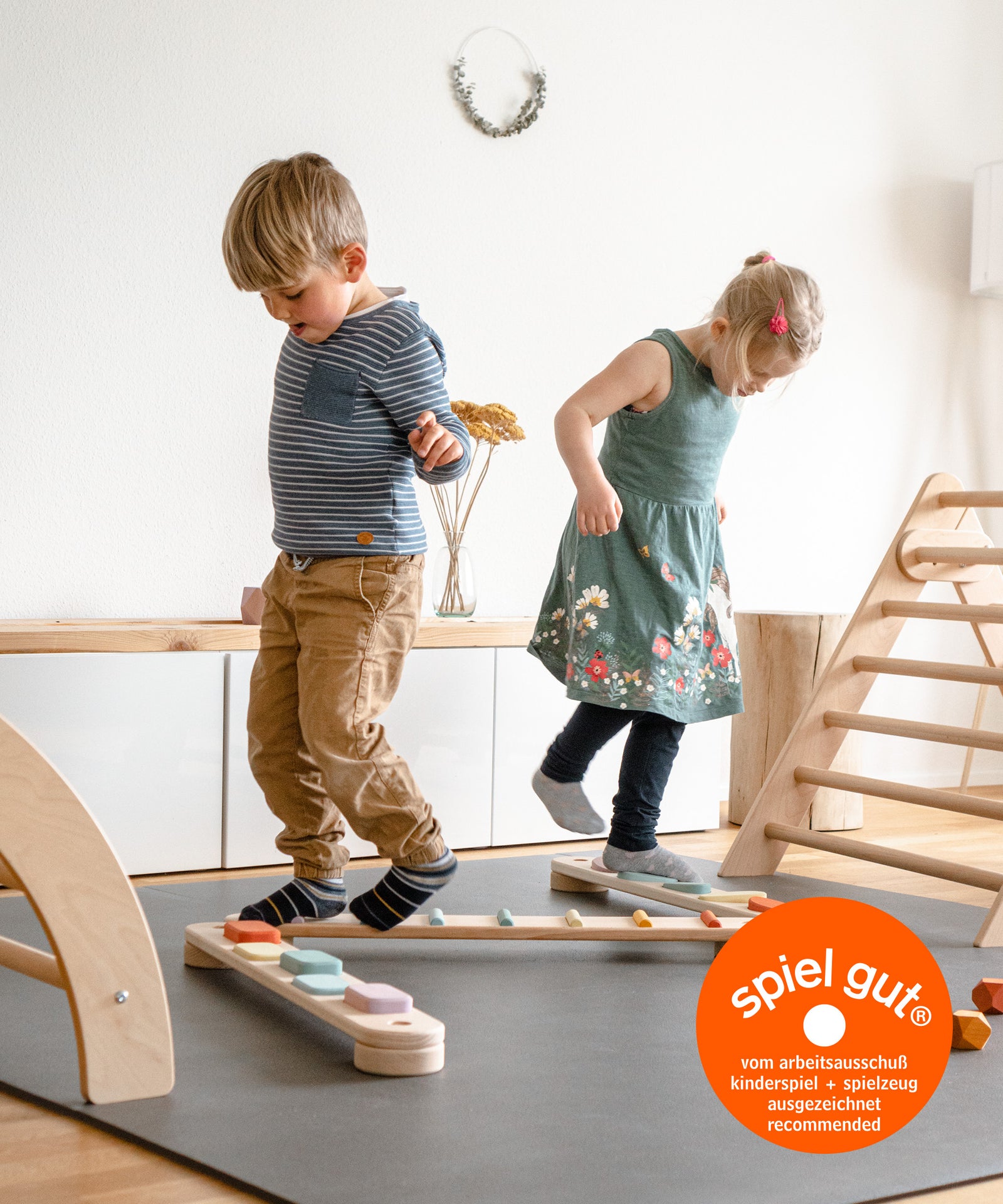 Vielseitig*Balancieren macht nicht nur Spaß, sondern fördert auch Gleichgewichtssinn und Koordination.|Zwei Kinder balancieren auf Balancierbalken, Balancierbalken ist spiel gut zertifiziert.