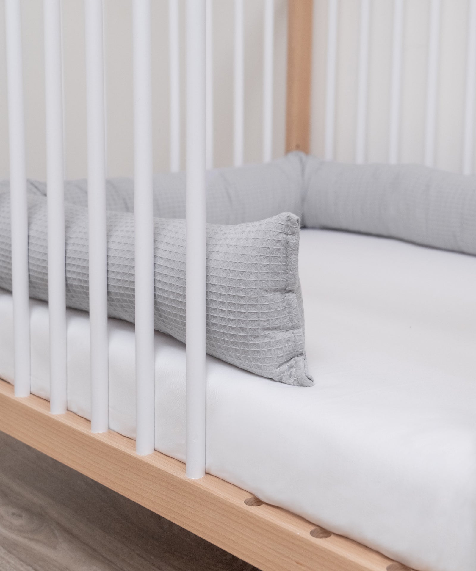 Pflegeleicht*Die Bettschlange ist bei 40 °C im Schonwaschgang in der Waschmaschine waschbar.|Bettschlange hellgrau liegt im Bett.