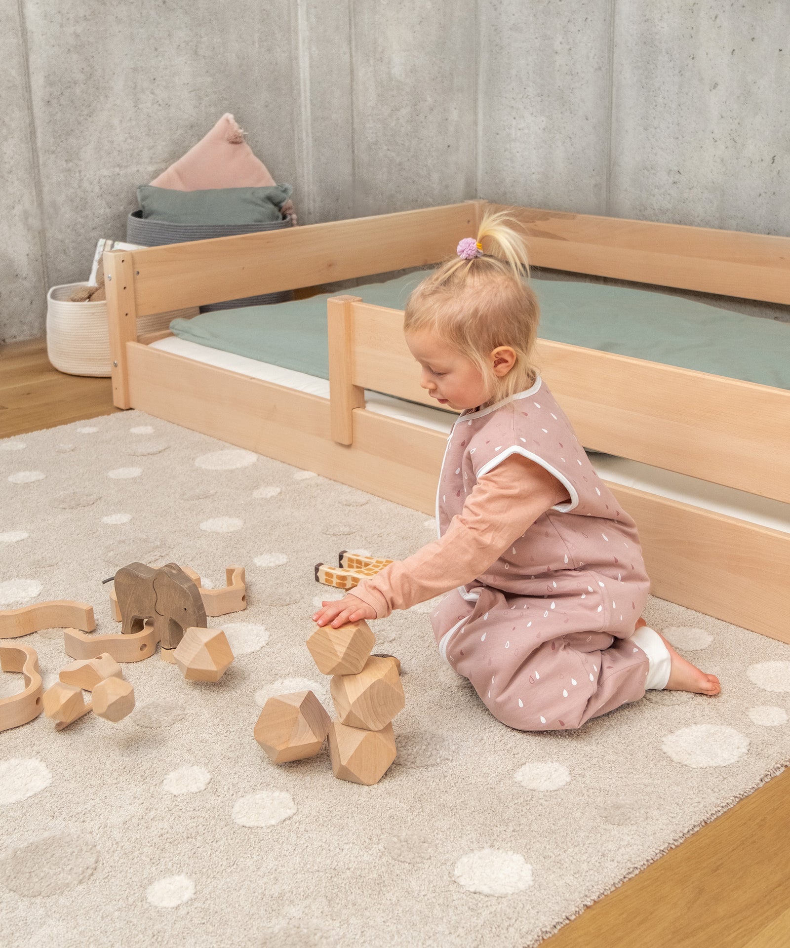 Mädchen spielt vor Bodenbett Buche für Kinder.