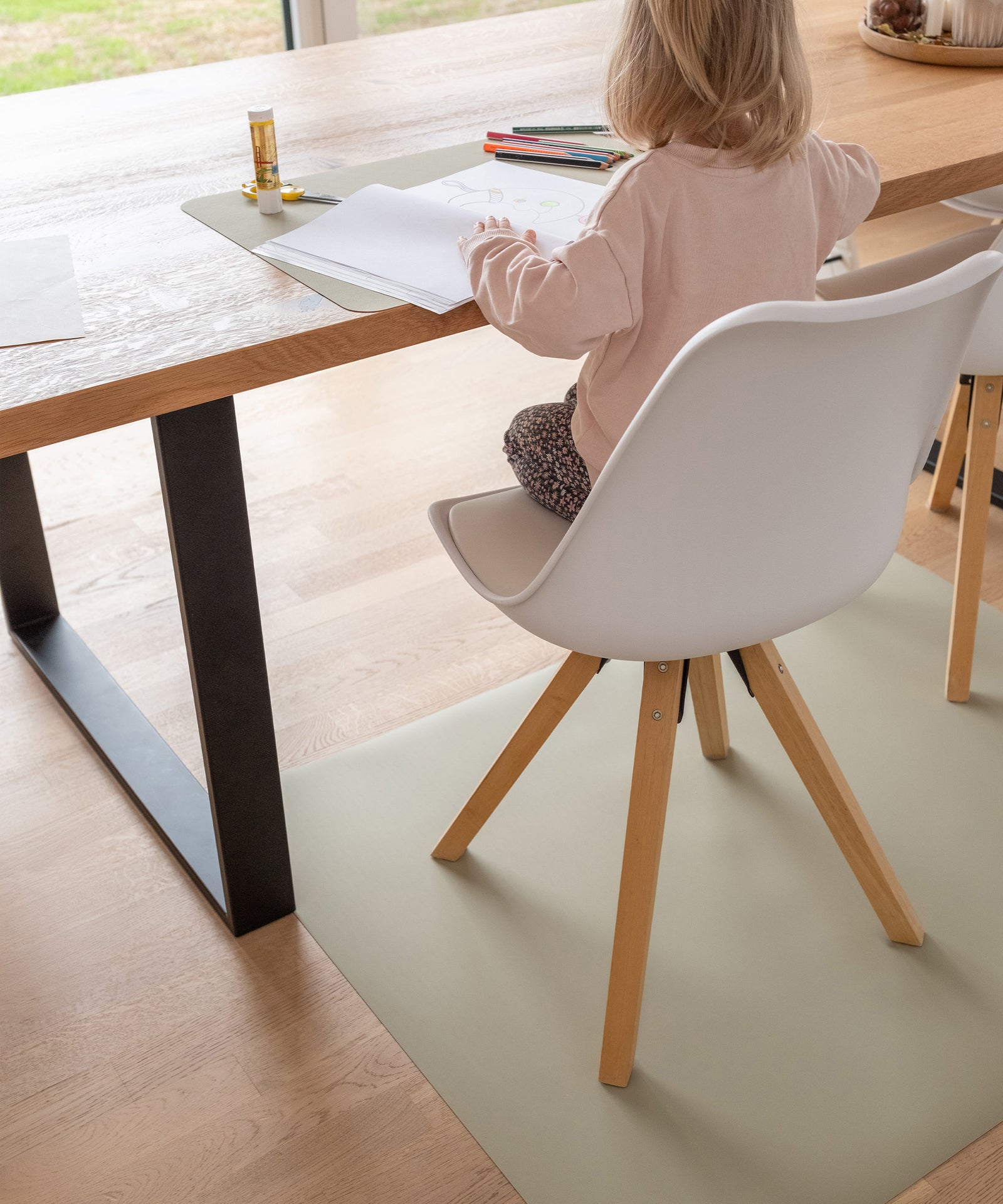 Bodenmatte an Esstisch unter normalem Stuhl.