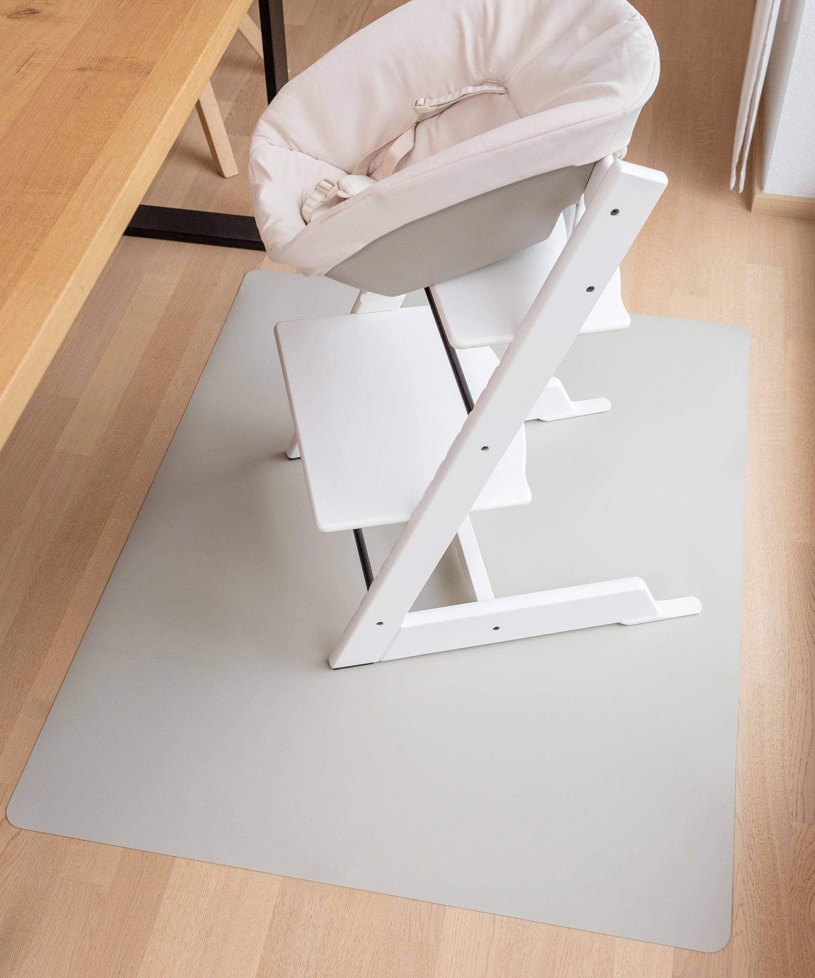 Lebensmittelecht & unbedenklich*Die schadstoffgeprüfte Bodenmatte ist unbedenklich für dein Kind. Das lebensmittelechte Material ist phthalatfrei und BPA-frei.|Hochstuhl steht auf Bodenschutzmatte in Hellgrau.