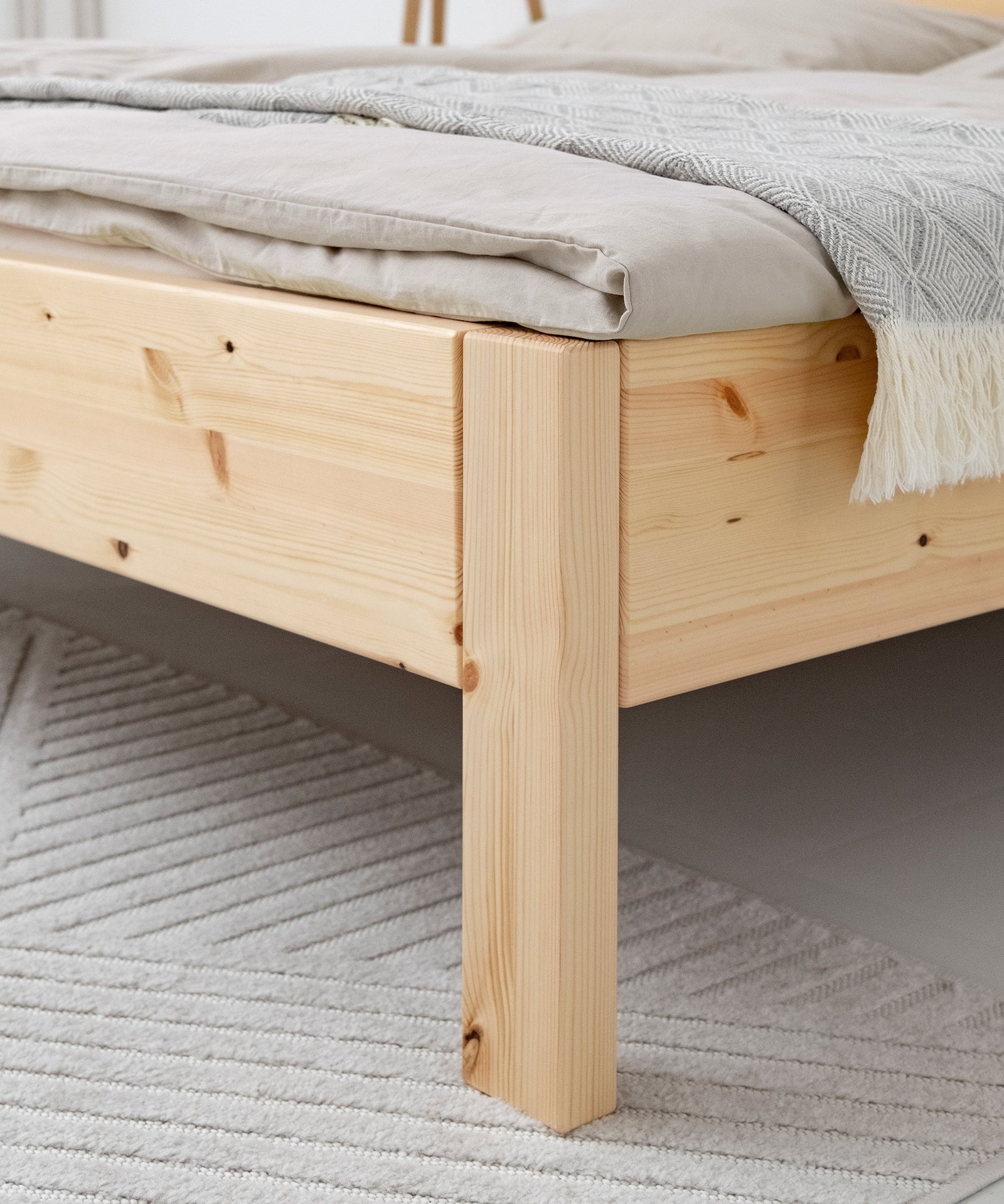 Hochwertig & langlebig*Unser Doppelbett wird aus nachhaltigem Kiefernholz gefertigt und mit kinderfreundlichem Lack überzogen.|Nahaufnahme Kiefernholz Natur transparent lackiert.