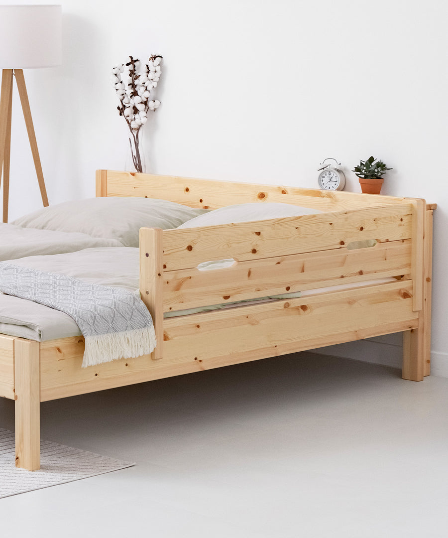 Rausfallschutz Kiefer natur transparent lackiert ganz einfach am Doppelbett angebracht.