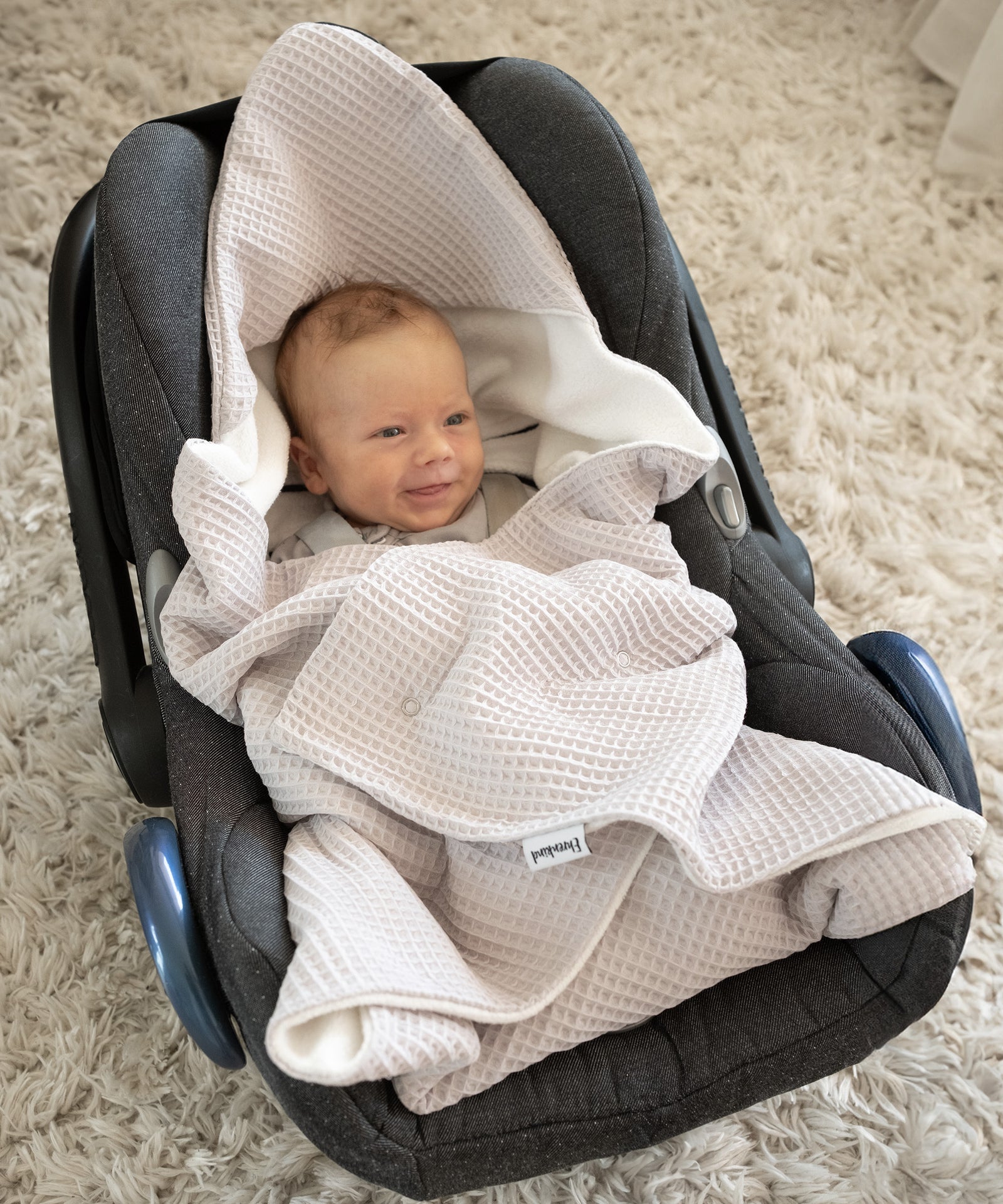 Universell einsetzbar*Praktischer Begleiter für unterwegs: Die Einschlagdecke ist universell einsetzbar und passend für alle gängigen Babyschalen.|Baby in Babyschale eingekuschelt in Einschlagdecke.