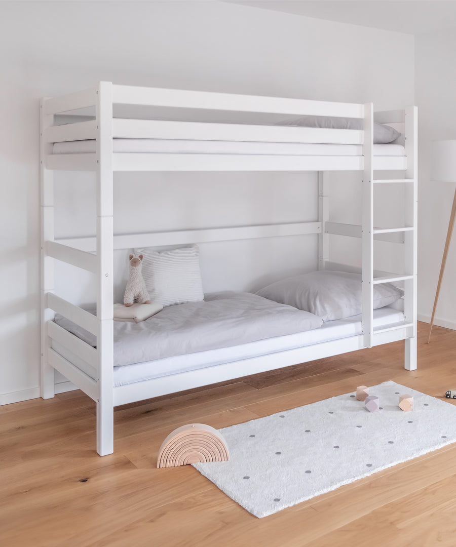 Raumwunder*Das Etagenbett bietet auf wenig Raum genügend Platz für zwei Schlafplätze und ist daher ideal für kleine Kinderzimmer.|Hohes Etagenbett in Weiß mit rechts montierter Leiter.