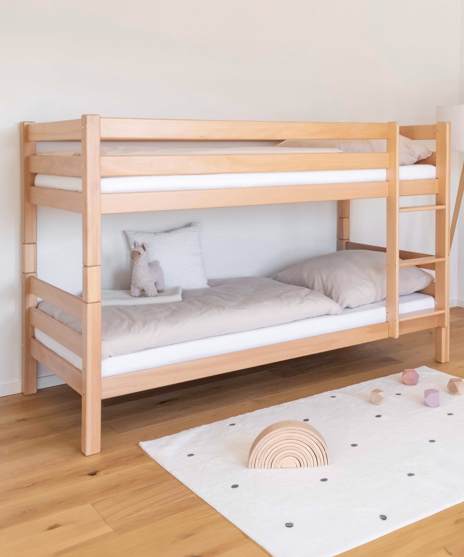 Raumwunder*Das Etagenbett bietet auf wenig Raum genügend Platz für zwei Schlafplätze und ist daher ideal für kleine Kinderzimmer.|Mittelhohes Etagenbett in Natur mit rechts montierter Leiter.