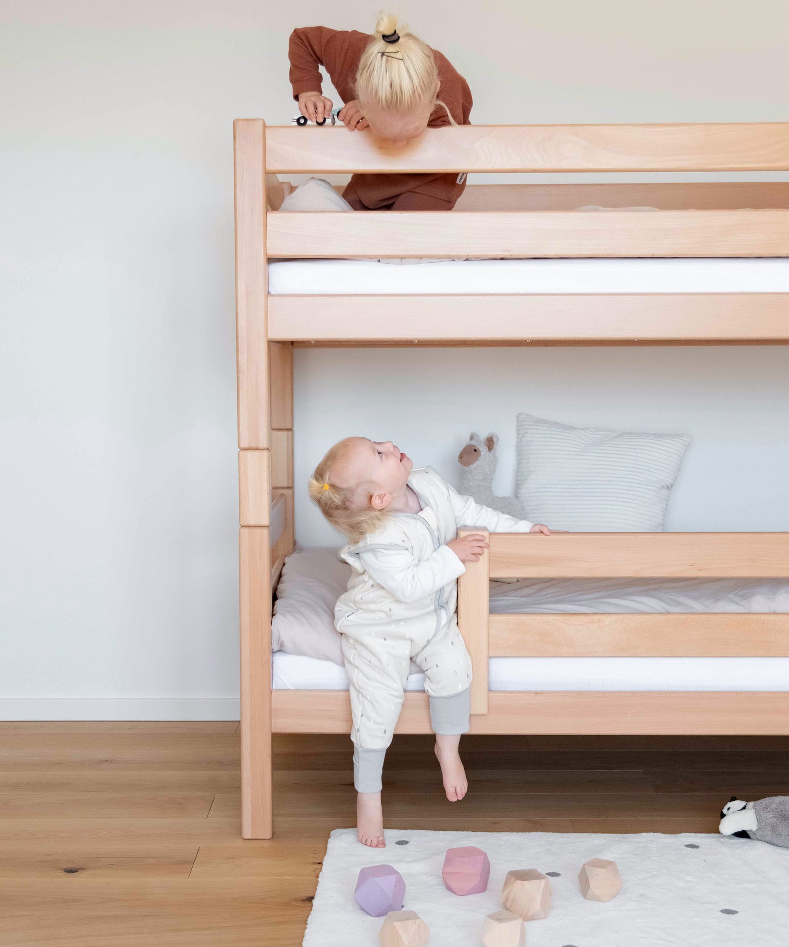Zwei Geschwister sind auf dem Etagenbett Mittelhoch, eines oben und eines unten.