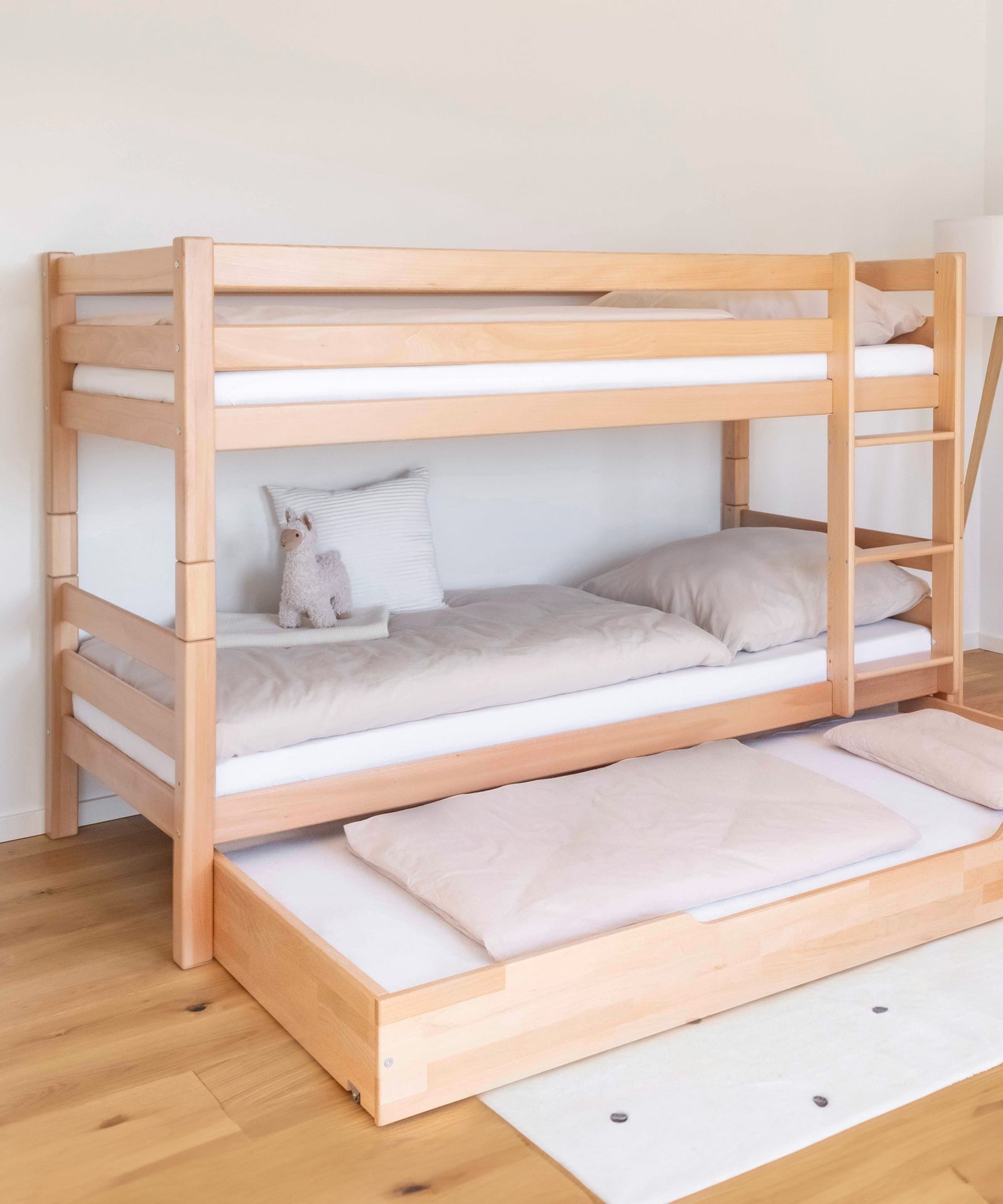 Etagenbett mittelhoch in der Farbe Natur mit ausgezogenem Bettkasten.