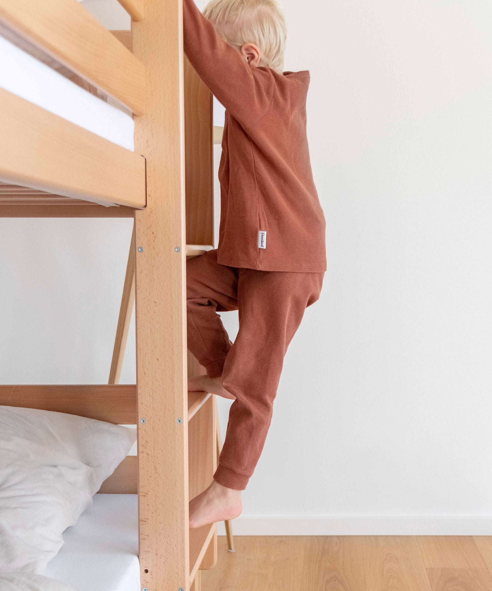 Trittsicher!*Dank unserer trittsicheren Leiter ist ein leichter und sicherer Einstieg für dein Kind garantiert.|Detailansicht der Leiter, auf der gerade ein Kind hoch steigt.