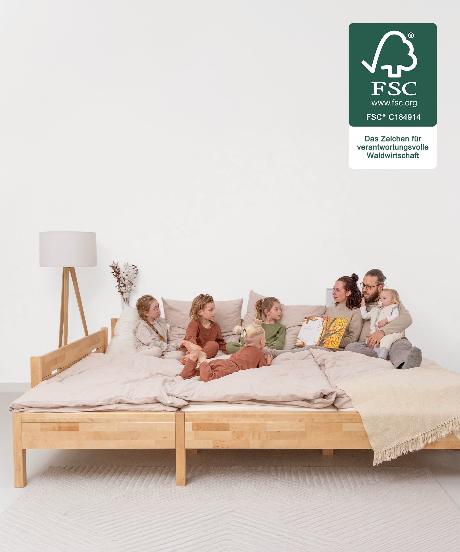 Platz für die ganze Familie*Das Familienbett bietet eine durchgehende, großzügige Liegefläche. So wird Co-Sleeping komfortabel und erholsam.|Familie auf Familienbett, Bett ist FSC zertifiziert.