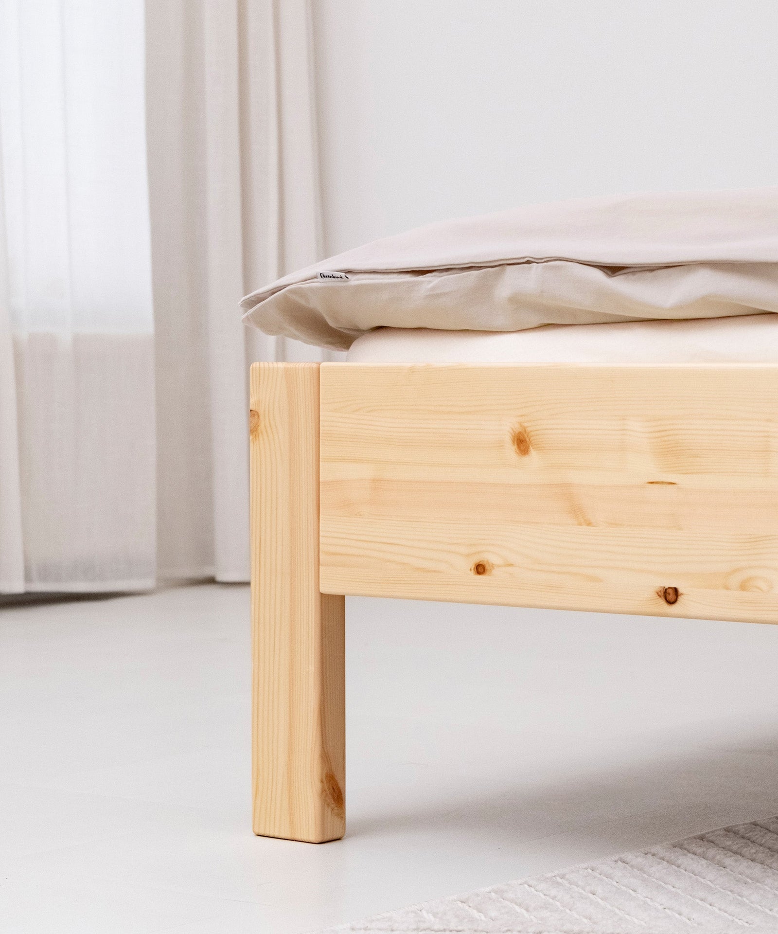 Hochwertig & langlebig*Unser Familienbett wird aus nachhaltigem Kiefernholz gefertigt und mit kinderfreundlichem Lack überzogen.|Nahaufnahme Fußende Familienbett Kiefer natur.