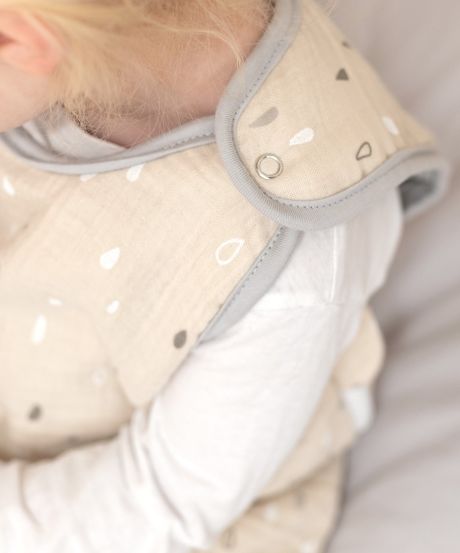 Praktische Druckknöpfe*Dank der Druckknöpfe ist der Schlafsack schnell angezogen, ohne ihn über den Kopf ziehen zu müssen - unkompliziert und stressfrei.|Nahaufnahme der Druckknöpfe des Schlafsacks.