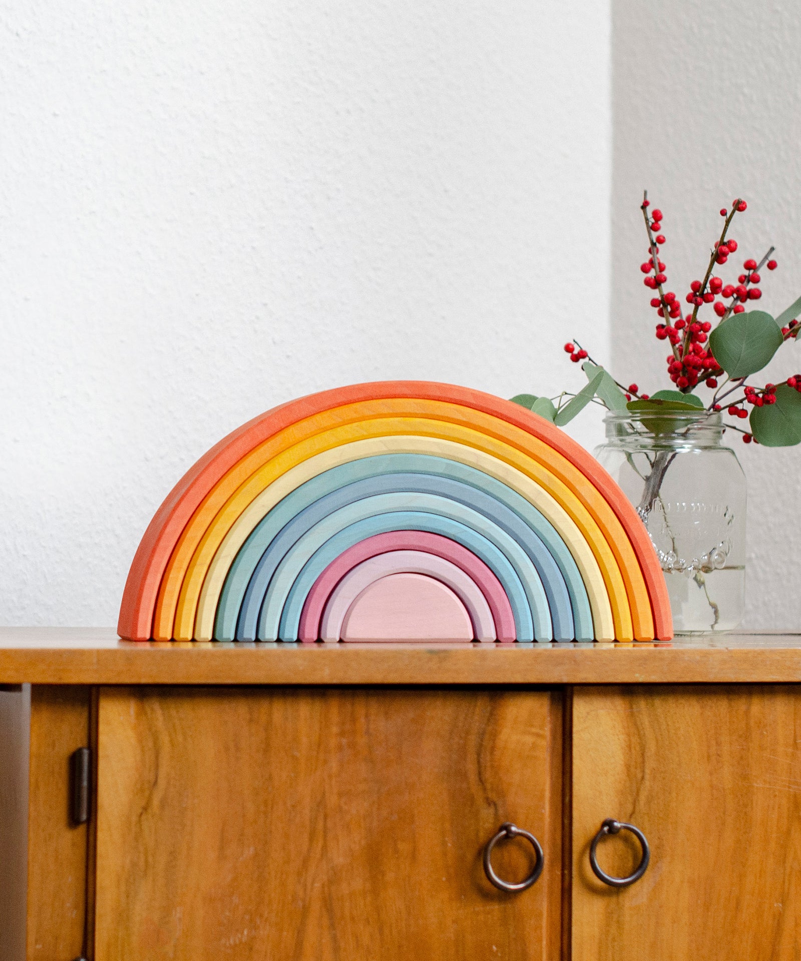 Formschönes Design*Alle Kanten und Flächen sind fein geschliffen. Die Farbgebung ist bewusst zart und betont den natürlichen Charakter des Holzes.|Regenbogen steht auf Schränkchen.