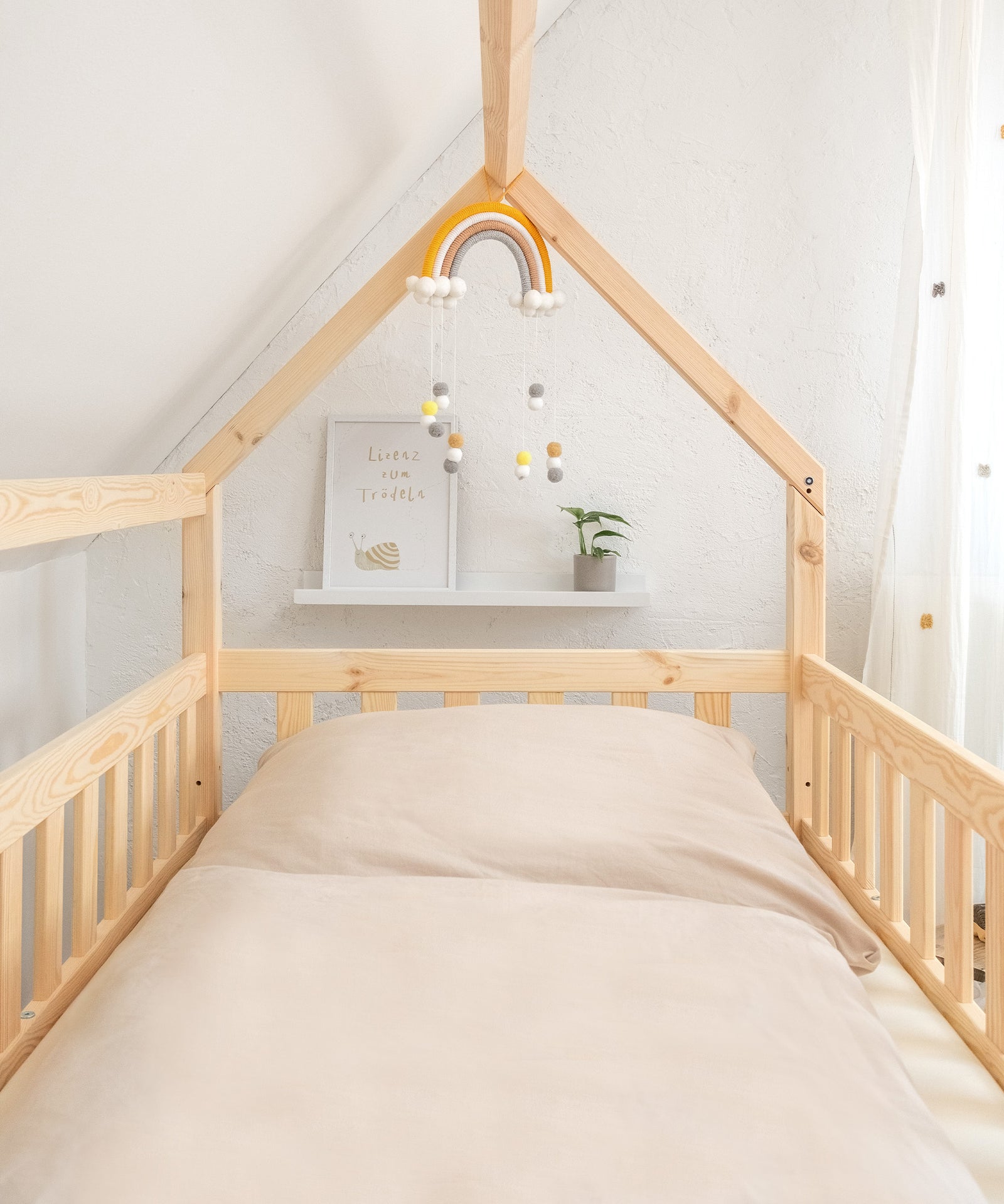 Hausbett Kiefer Natur mit Deko und Bettwäsche.