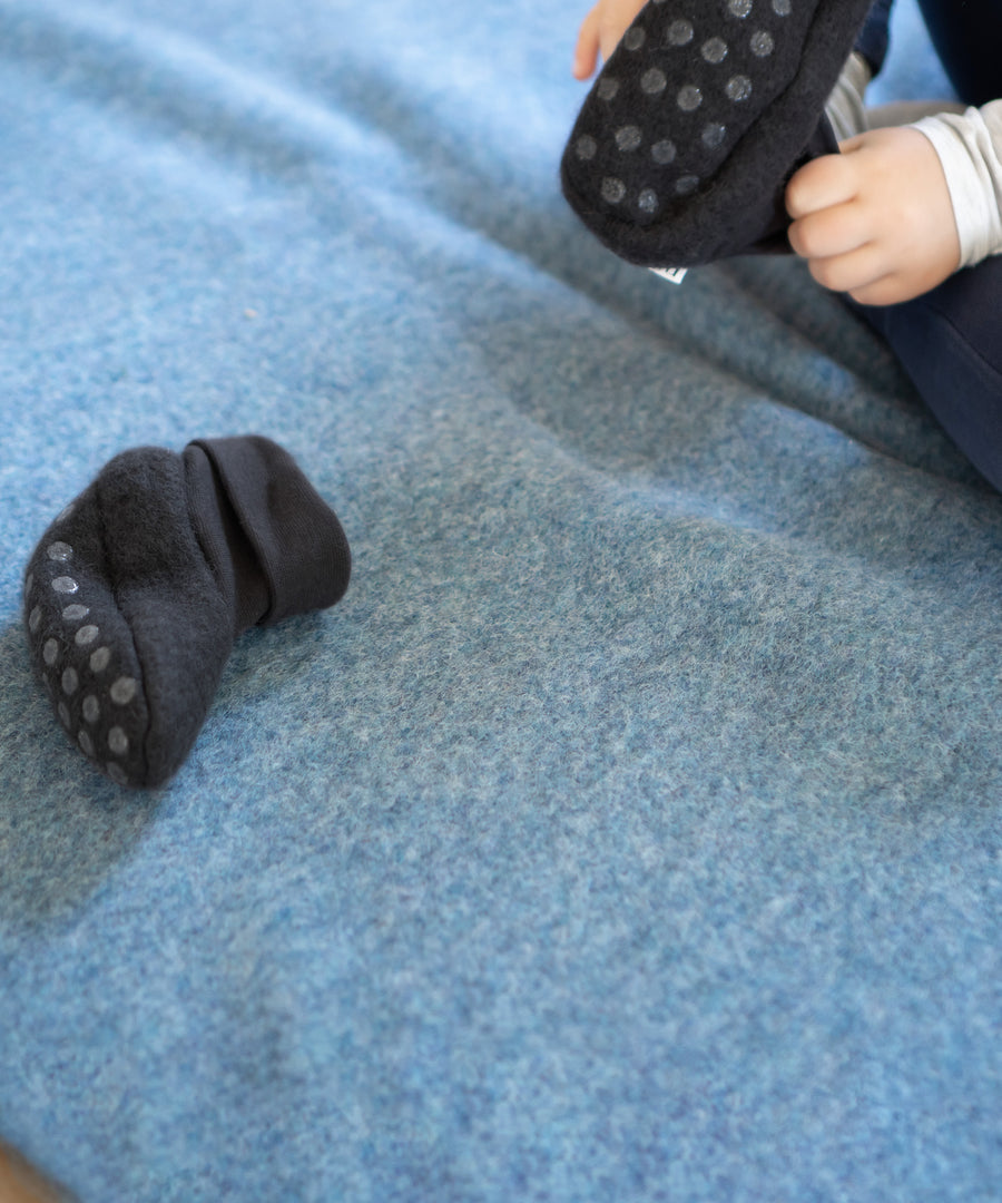 Reinschlüpfen & los geht’s*Mit elastischem Bündchen lassen sie sich ganz einfach an- und aus-ziehen, so dass dein Kind schon bald eigenständig hineinschlüpfen kann.|Kind zieht Walkschühchen selbstständig an.