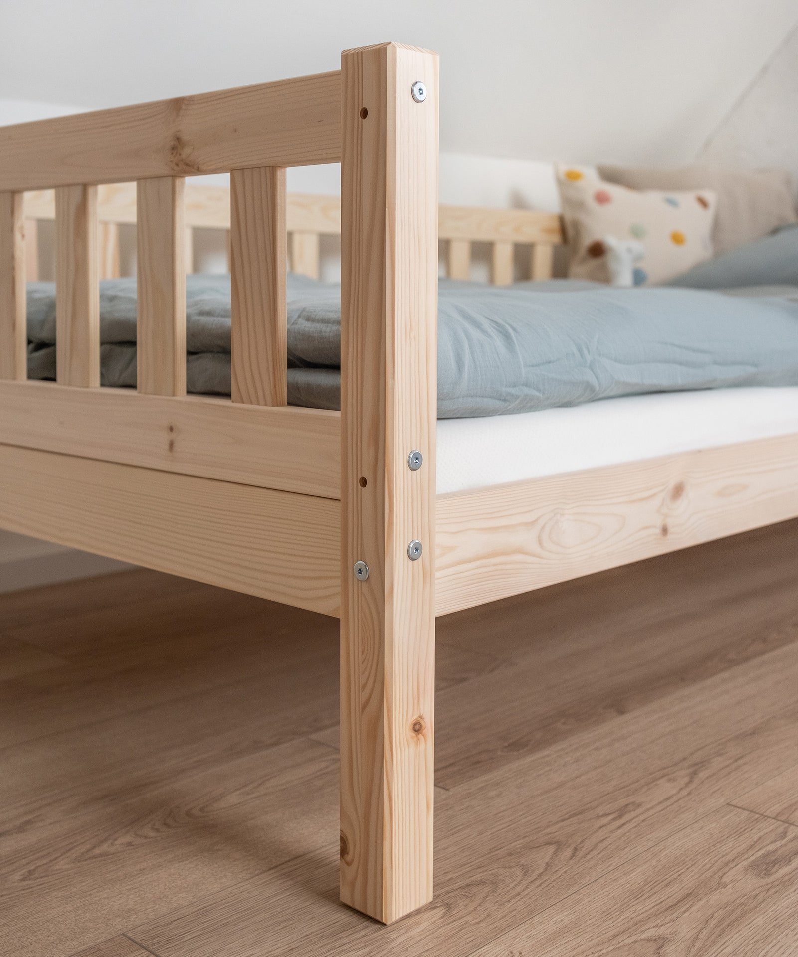 Hochwertiges Kiefernholz*Unser Kinderbett wird aus nachhaltigem und massivem Kiefernholz unter fairen Arbeitsbedingungen gefertigt.|Nahaufnahme Kiefernholz vom Kinderbett Kiefer Natur.