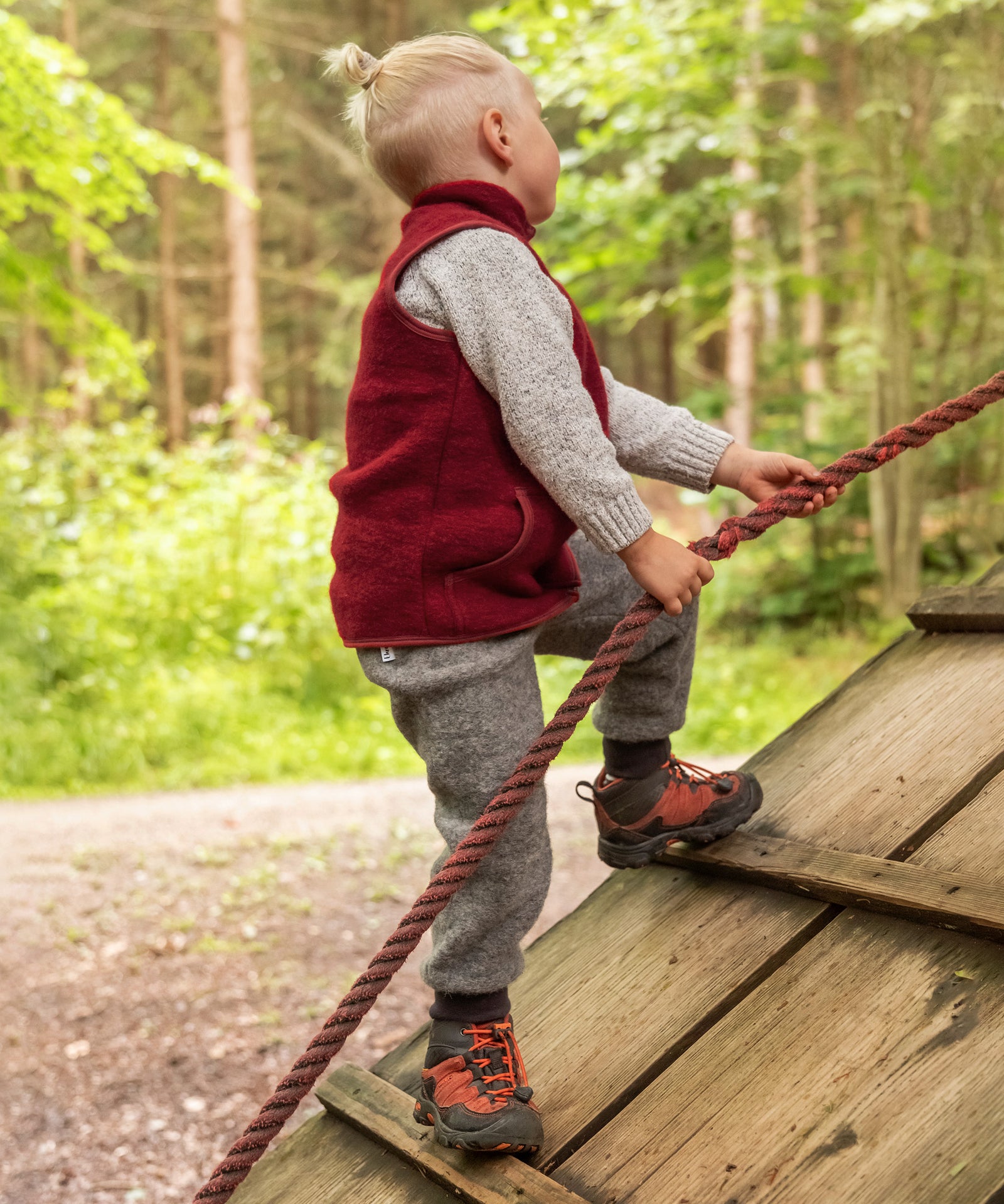 Kind klettert am Seil hoch.