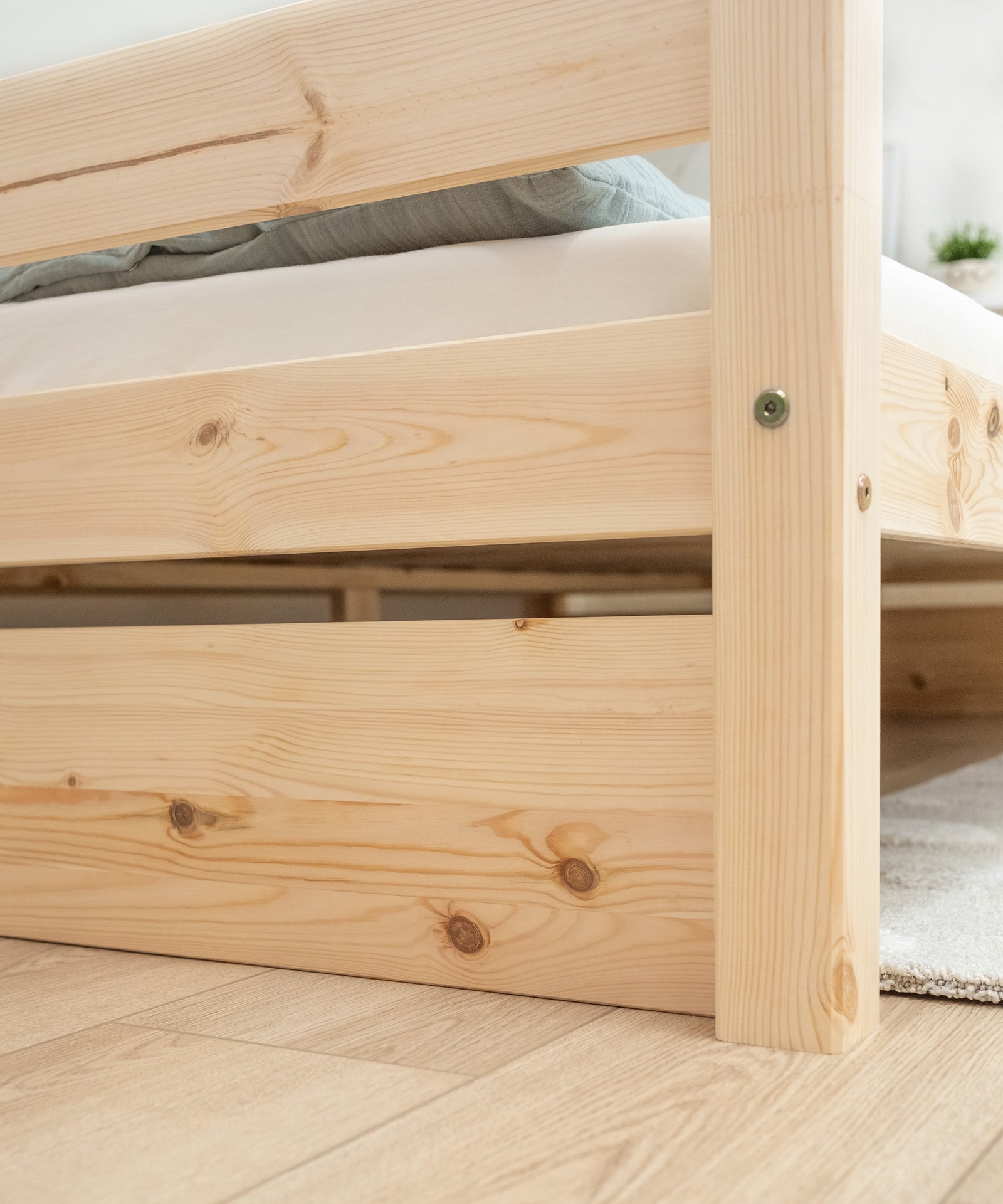 Hochwertiges Kiefernholz*Unser Kinderbett wird aus massivem, FSC® zertifiziertem Kiefernholz unter fairen Arbeitsbedingungen gefertigt.|Nahaufnahme Kiefernholz vom Kinderbett K3 Natur.