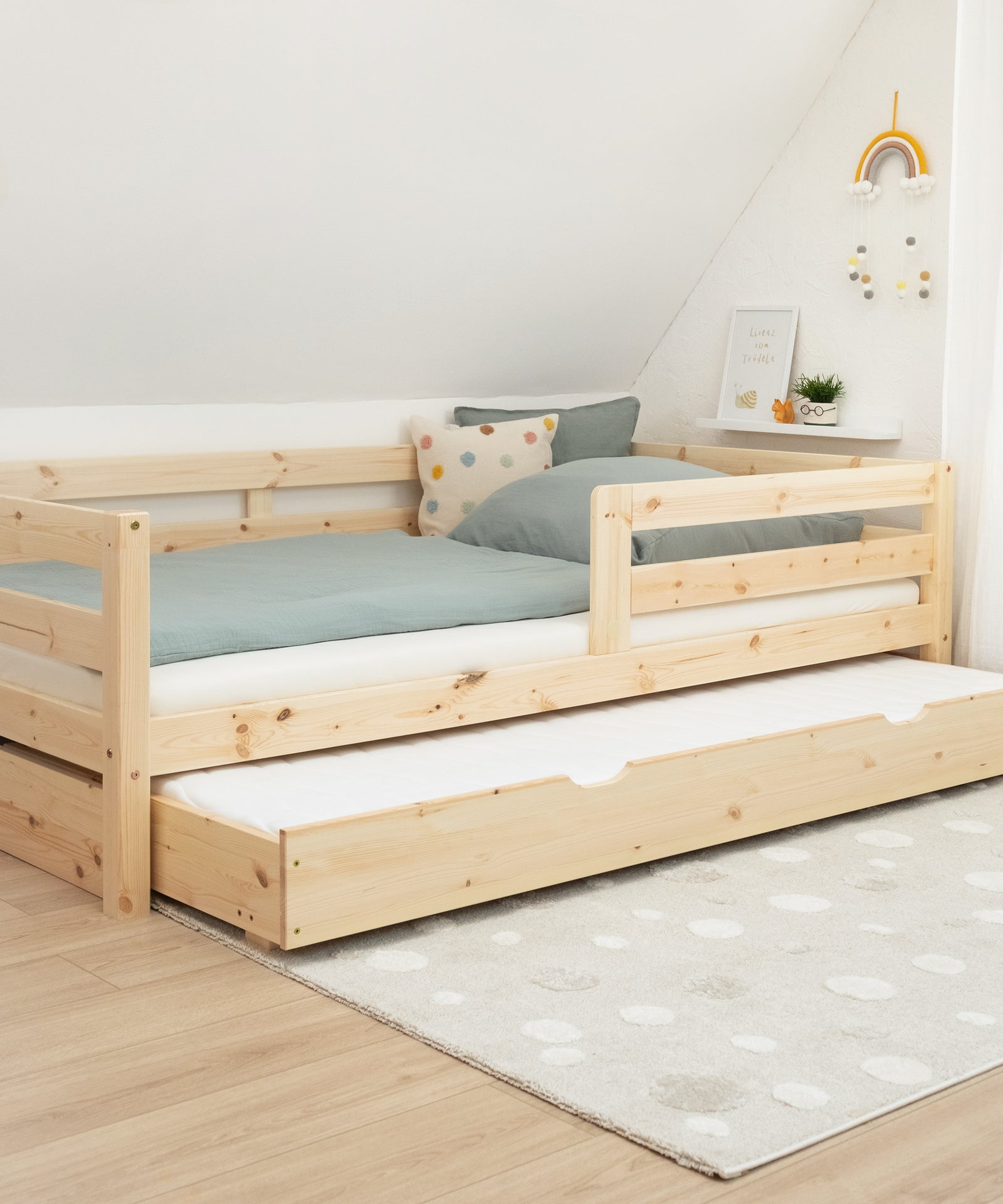 Zusätzlicher Schlafplatz*Unser optionaler Bettkasten bietet weitere Stauraumfläche oder einen extra Schlafplatz.|Kinderbett mit Ausziehbett im Bettkasten.