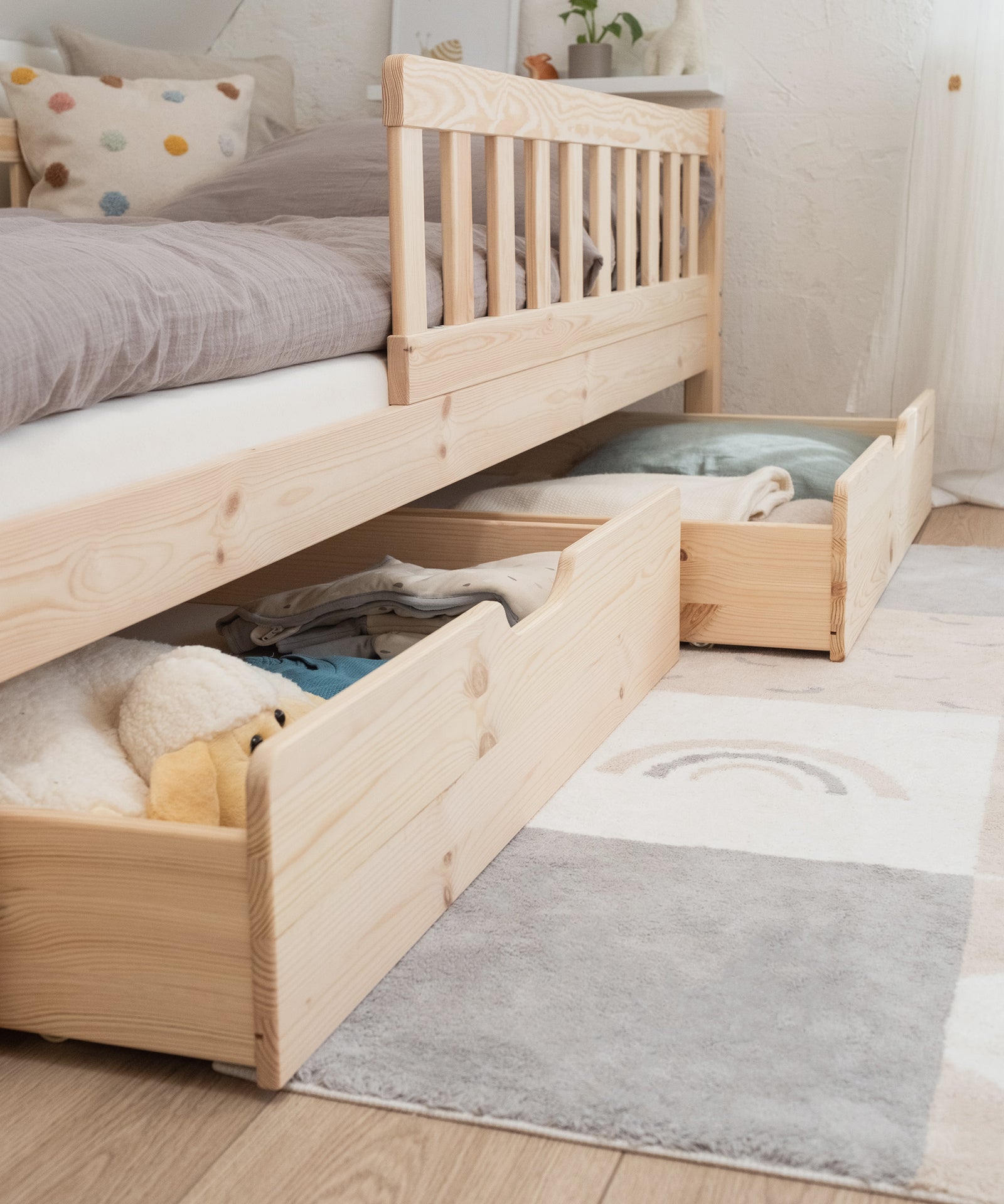 Extra Stauraum*Unsere optionalen Bettschubladen bieten zusätzlichen Stauraum für Groß und Klein.|Nahaufnahme der halb ausgezogenen Doppelschublade in Kiefer Natur.