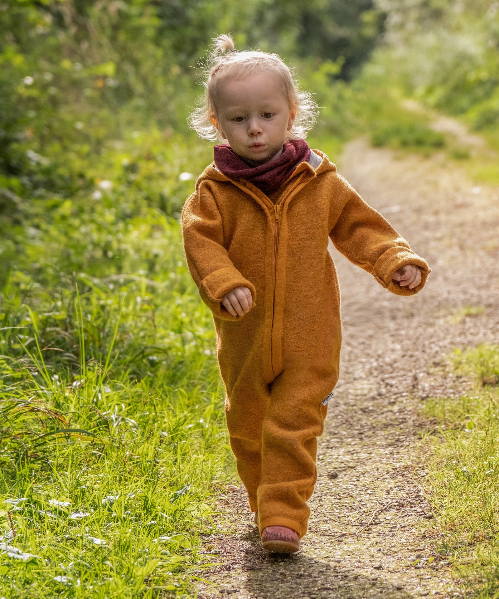 Made in Germany*Der hochwertige Schlauchschal im zeitlosen Design wird in Deutschland produziert.|Mädchen mit Walkoverall und Schlauchschal auf Waldweg.