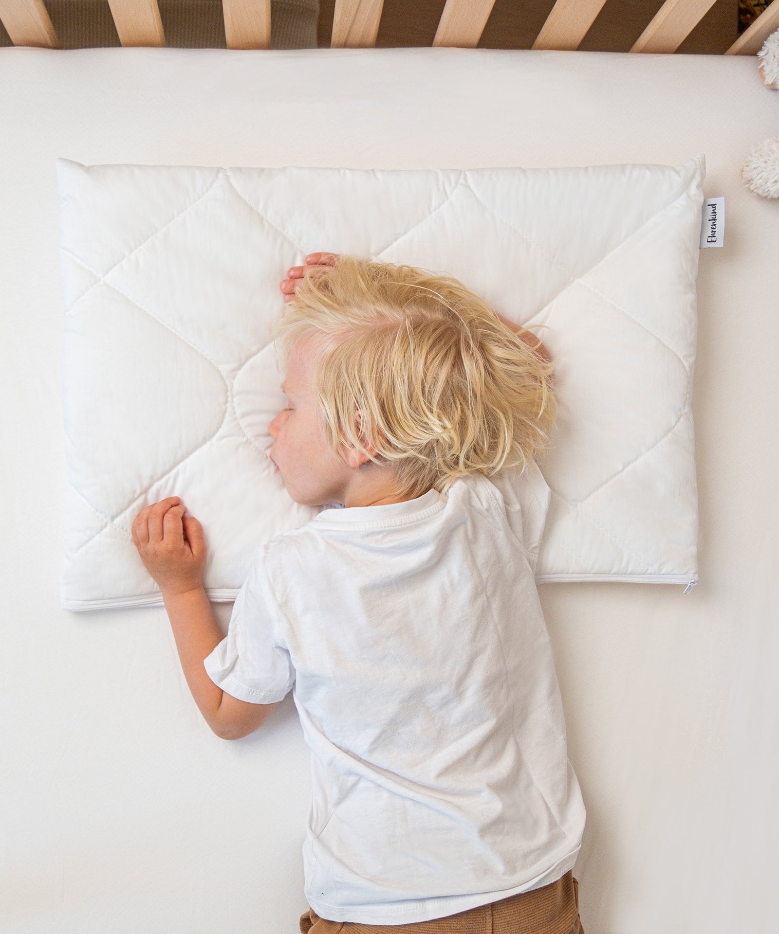 Für Bauchschläfer*Durch die drei herausnehmbaren Innenkissen kann die Kissenhöhe individuell an die Schlafposition von Bauchschläfern angepasst werden.|Junge schläft auf dem Bauch auf höhenverstellbarem Kissen.