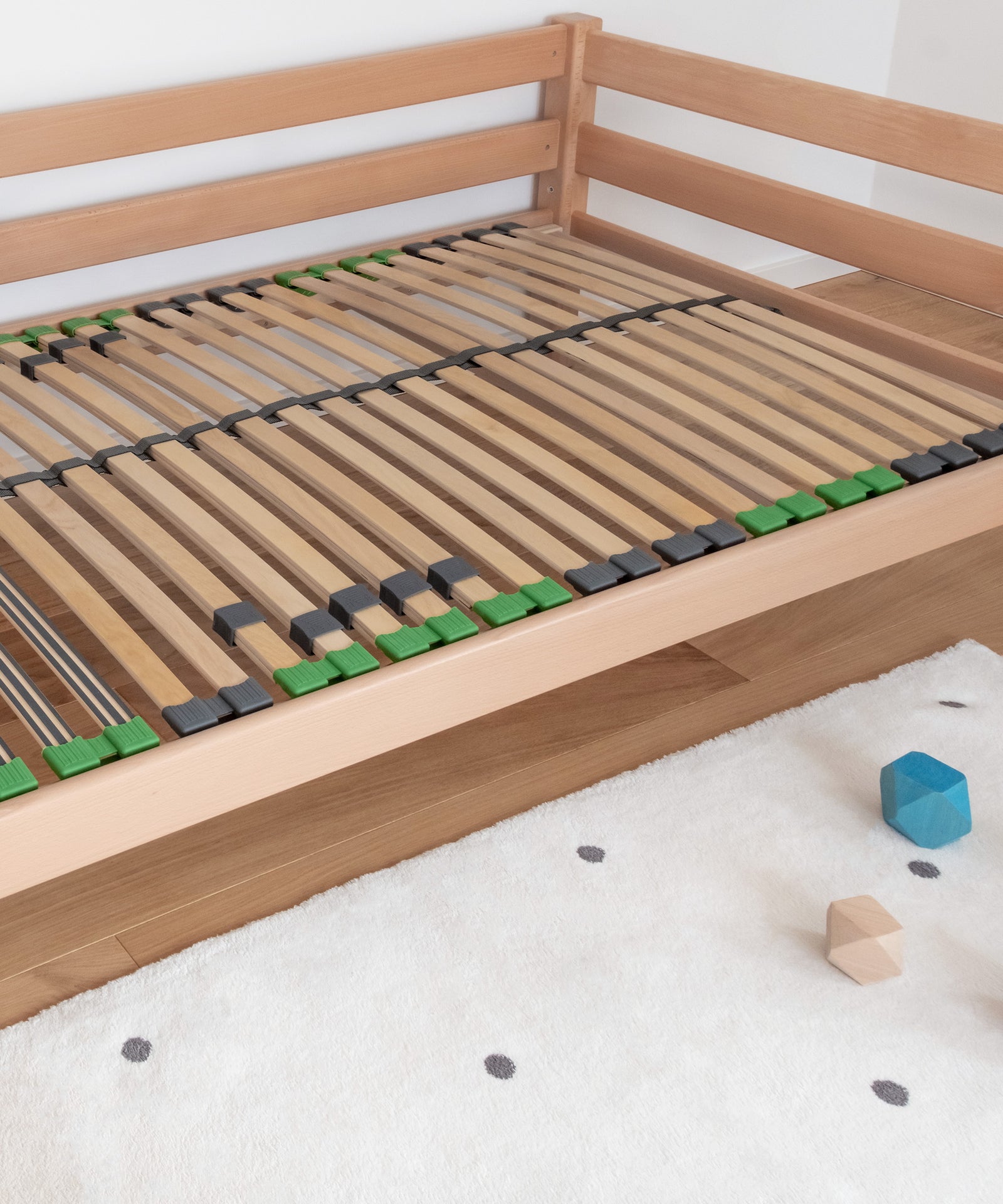 Hohe Stabilität*Dank durchgängiger Holme und der Verwendung von Qualitätsholz ist der Lattenrost besonders stabil.|Montierter Lattenrost liegt in Kinderbett.