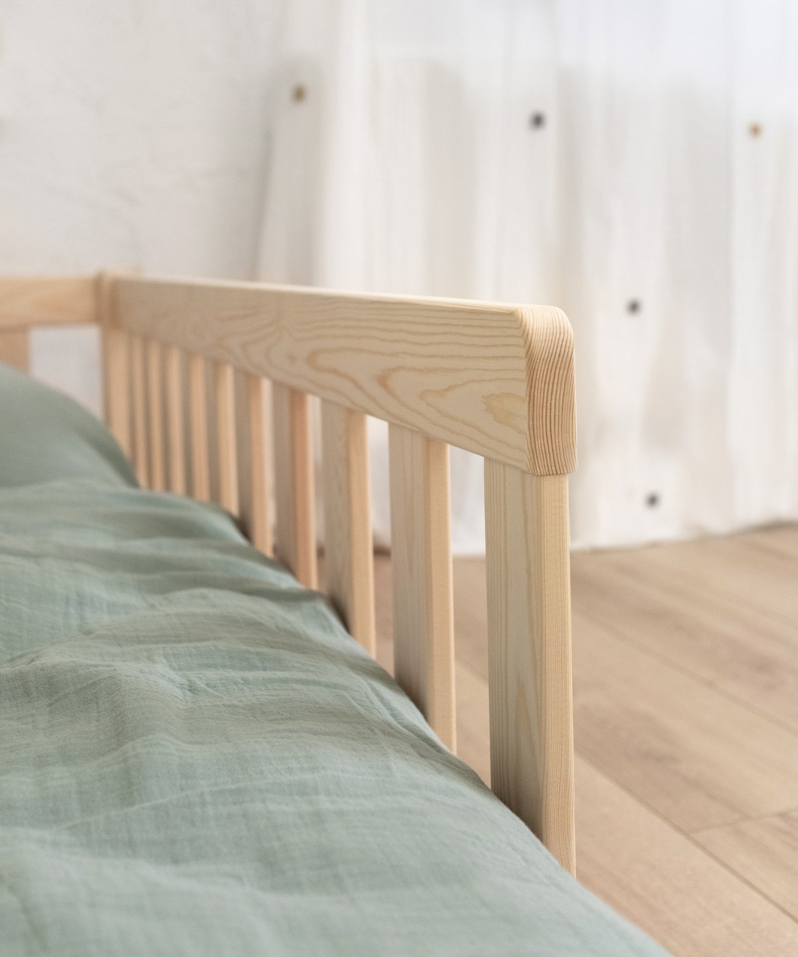 Nahaufnahme Rausfallschutz am Montessori Bodenbett aus Kiefer.