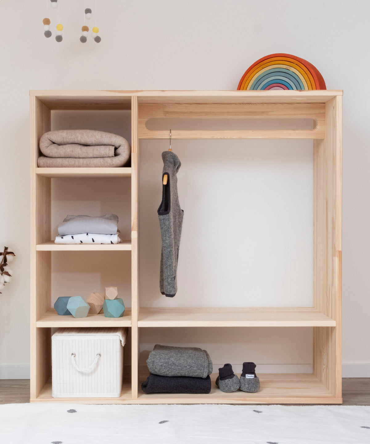 Montessori Kleiderschrank Kiefer mit Kleidung und Accessoires befüllt.