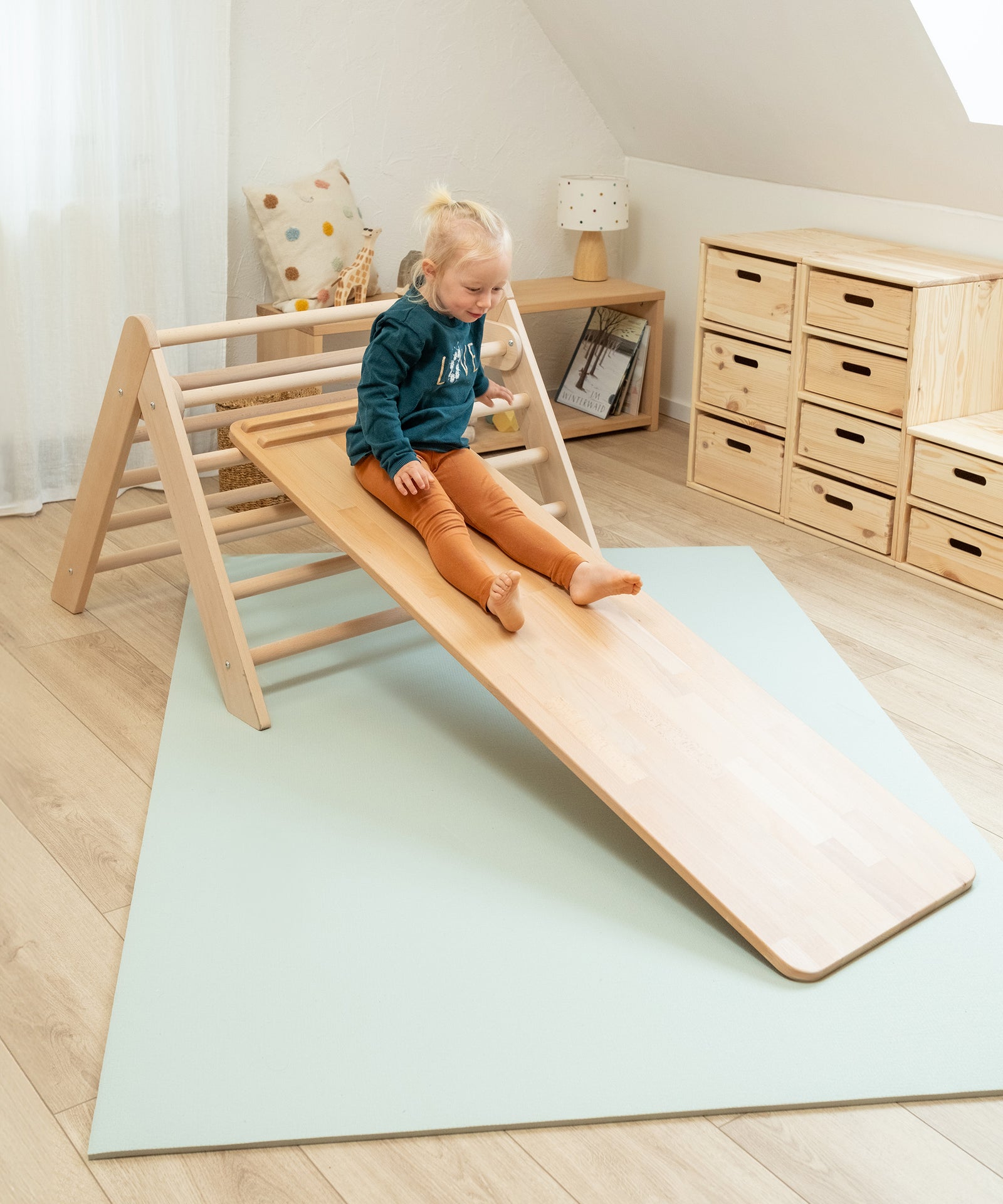 Kind rutscht auf dem Rutschbrett herunter.