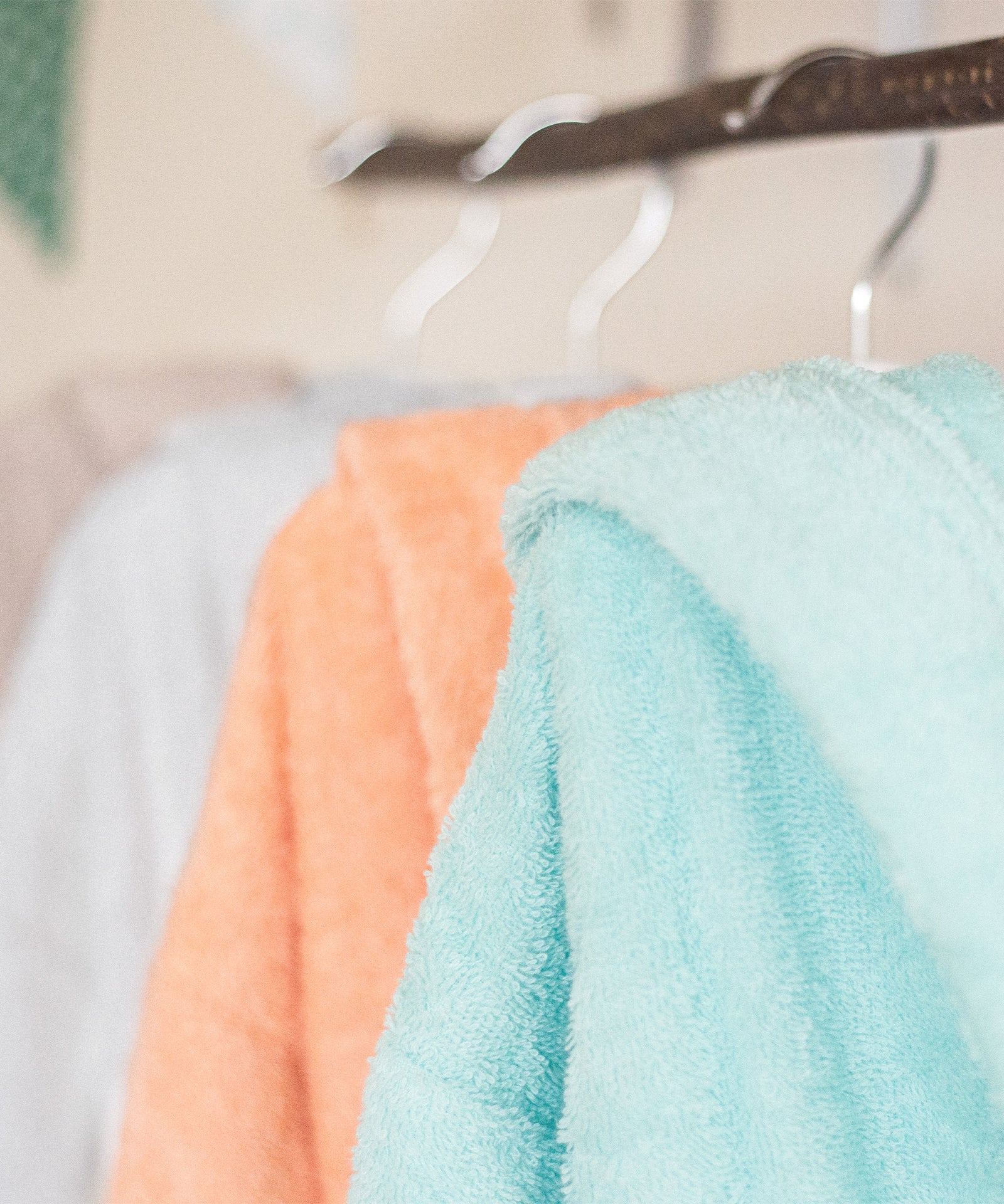 Frische Farben*Ob in Poolblau, Hellgrau, Coral, Sandbraun oder Vanille - mit dem Ehrenkind Bademantel ist für jeden Geschmack etwas dabei.|Der Bademantel hängt in verschiedenen Farben im Schrank.