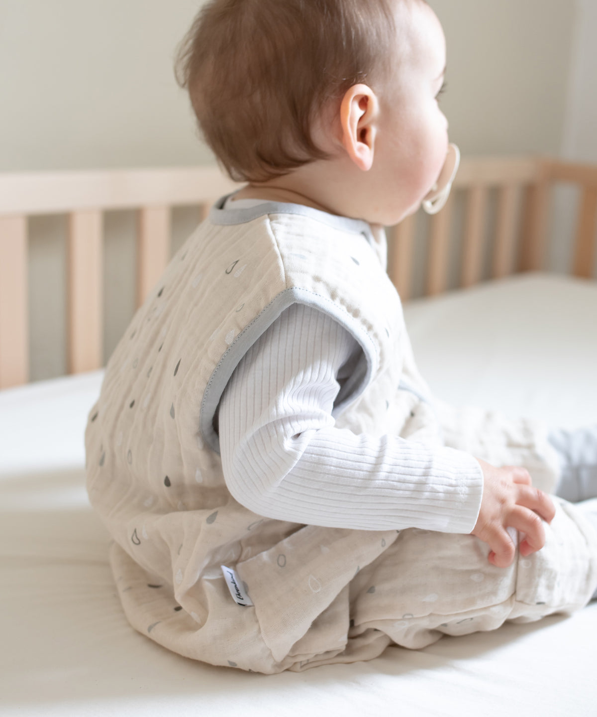 Baby mit Musselin Schlafsack in Farbe Natur Tropfen.