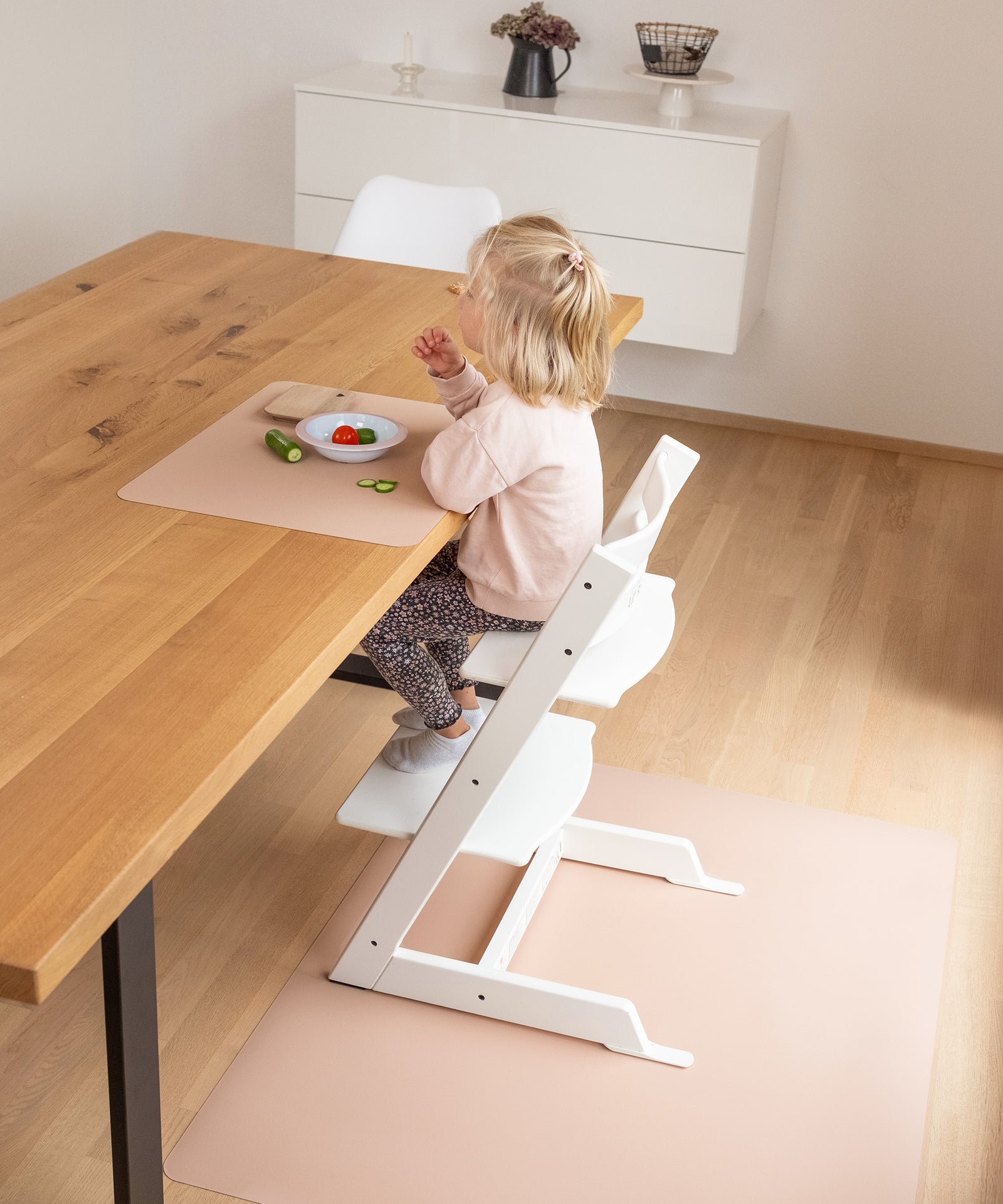 Ein Kind isst am Tisch auf einem Tischset.