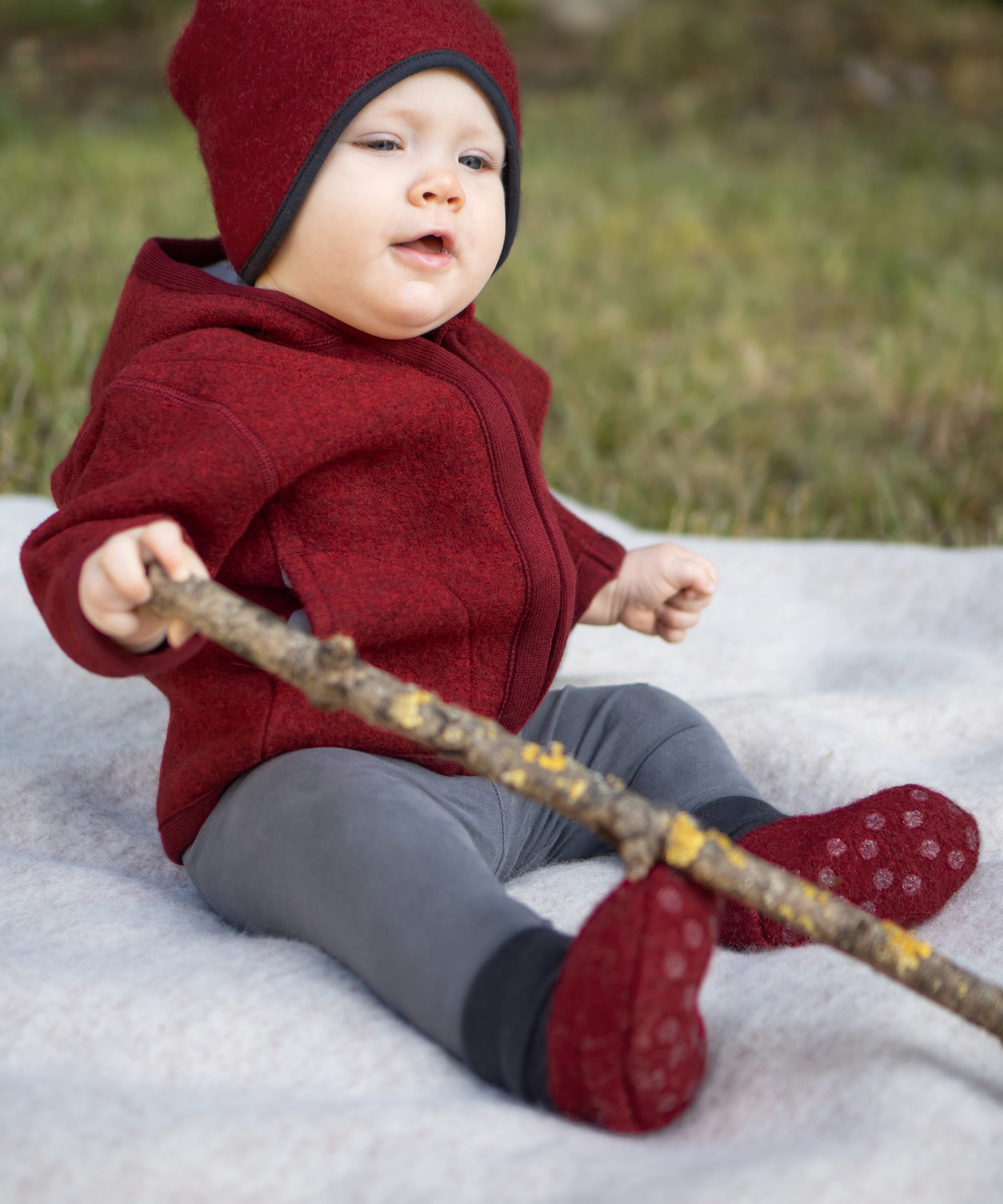 Baby sitzt auf einer Decke.