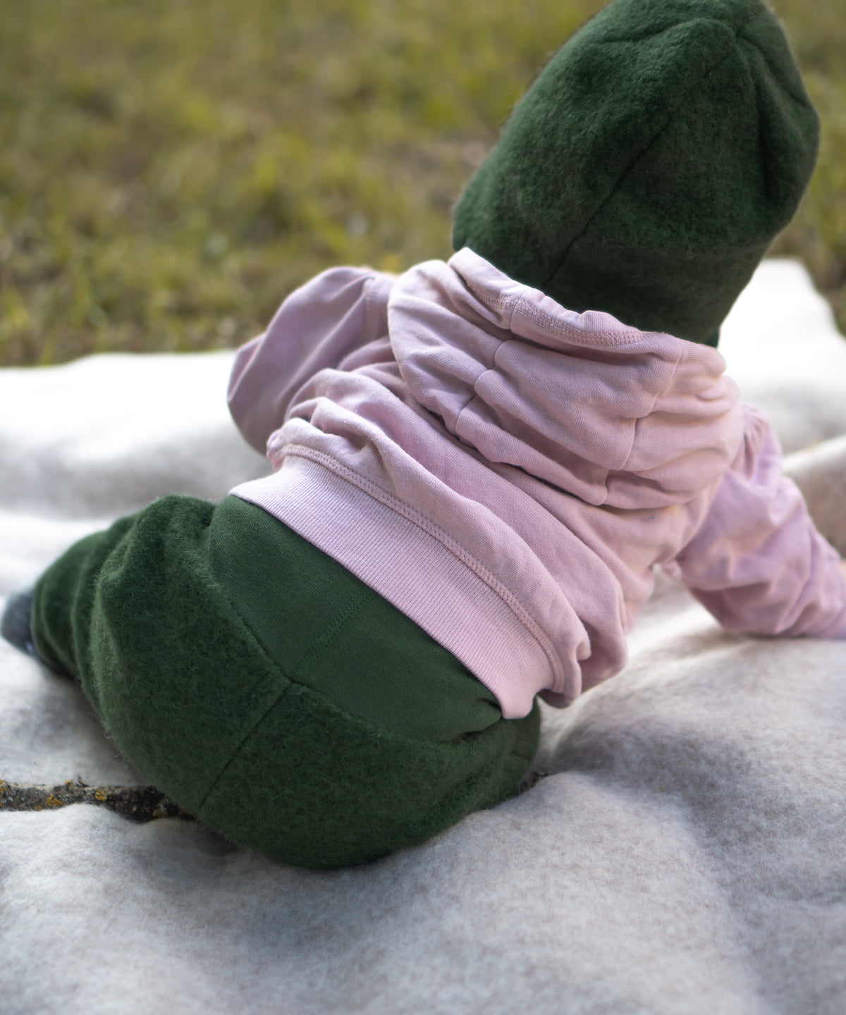 Rückansicht von Baby mit Walkhose auf einer Decke.