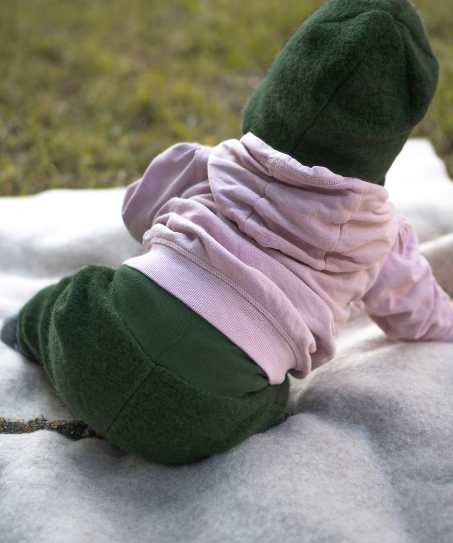 Rückansicht von Baby mit Walkhose auf einer Decke.