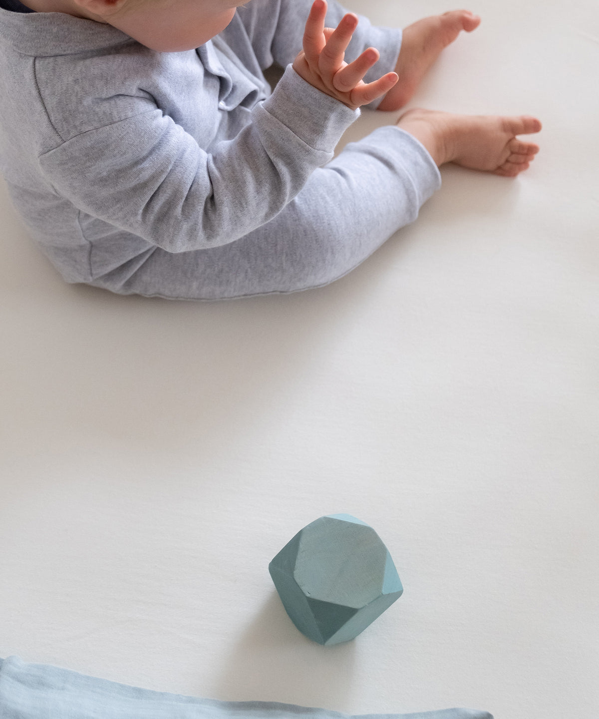 100 % Bio-Baumwolle*Die atmungsaktive Bio-Baumwolle ist angenehm weich, hautfreundlich und temperaturausgleichend.|Baby sitzt auf Spannbettlaken.