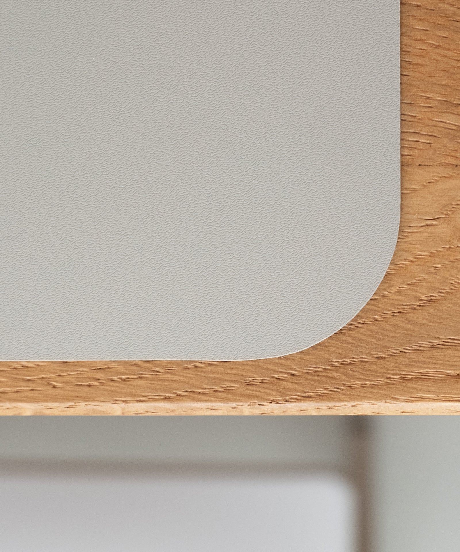 Robust & rutschfest*Das strapazierfähige Material mit rutschhemmender Unterseite ist robust und kratzfest - es hält den Familienalltag bestens aus.|Nahaufnahme der rutschfesten und robusten Oberfläche eines Tischsets auf Holz.