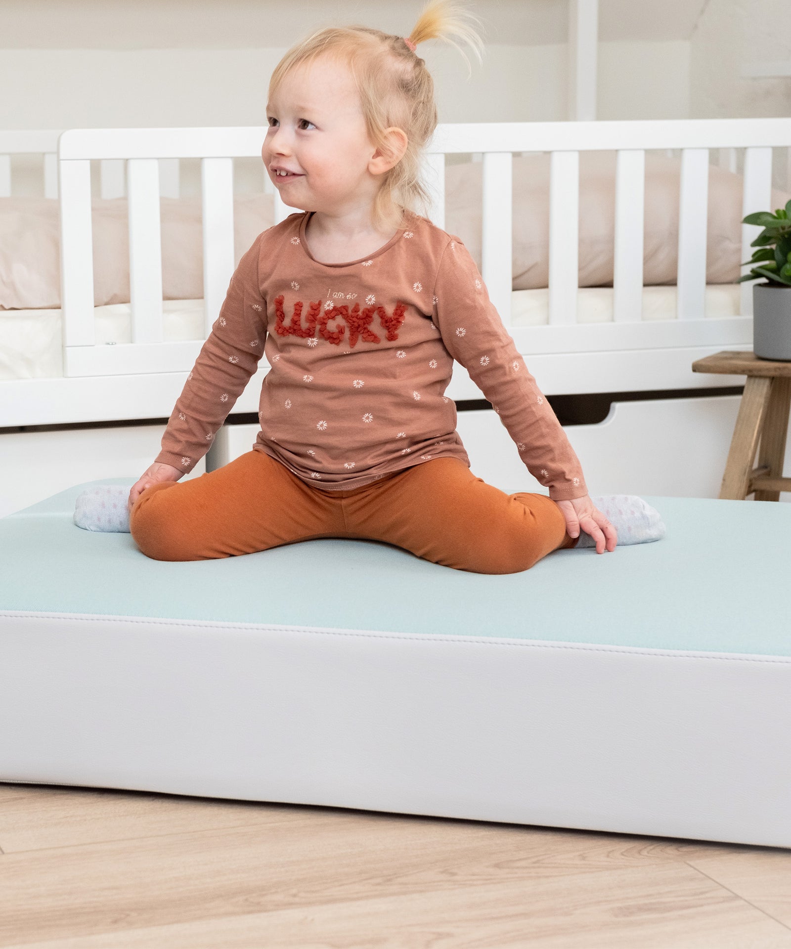 Mädchen sitzt auf Hüpfkissen.